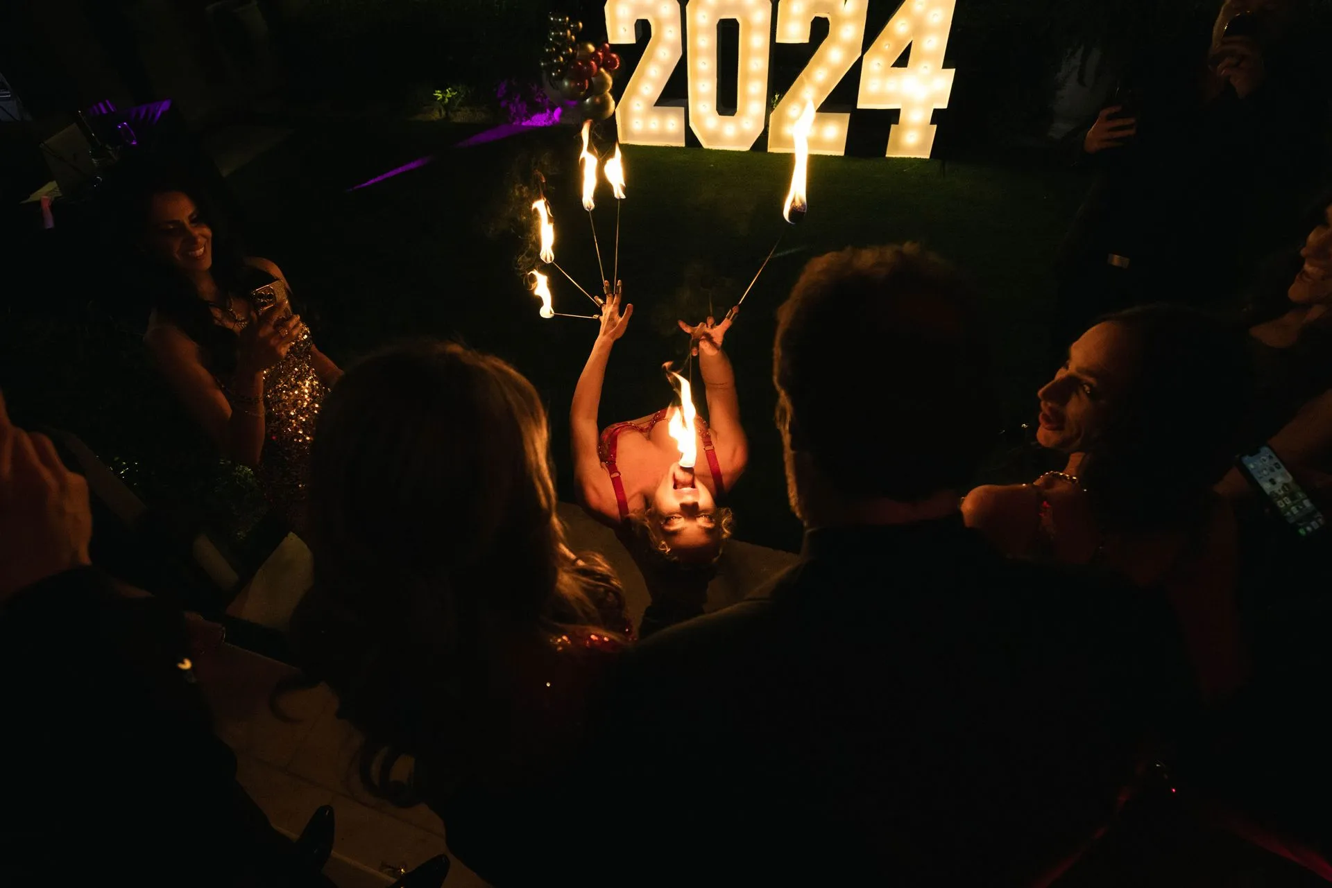 Guests gathered around a fire performer's finale moment at a corporate New Year's Eve event produced by Hana Events