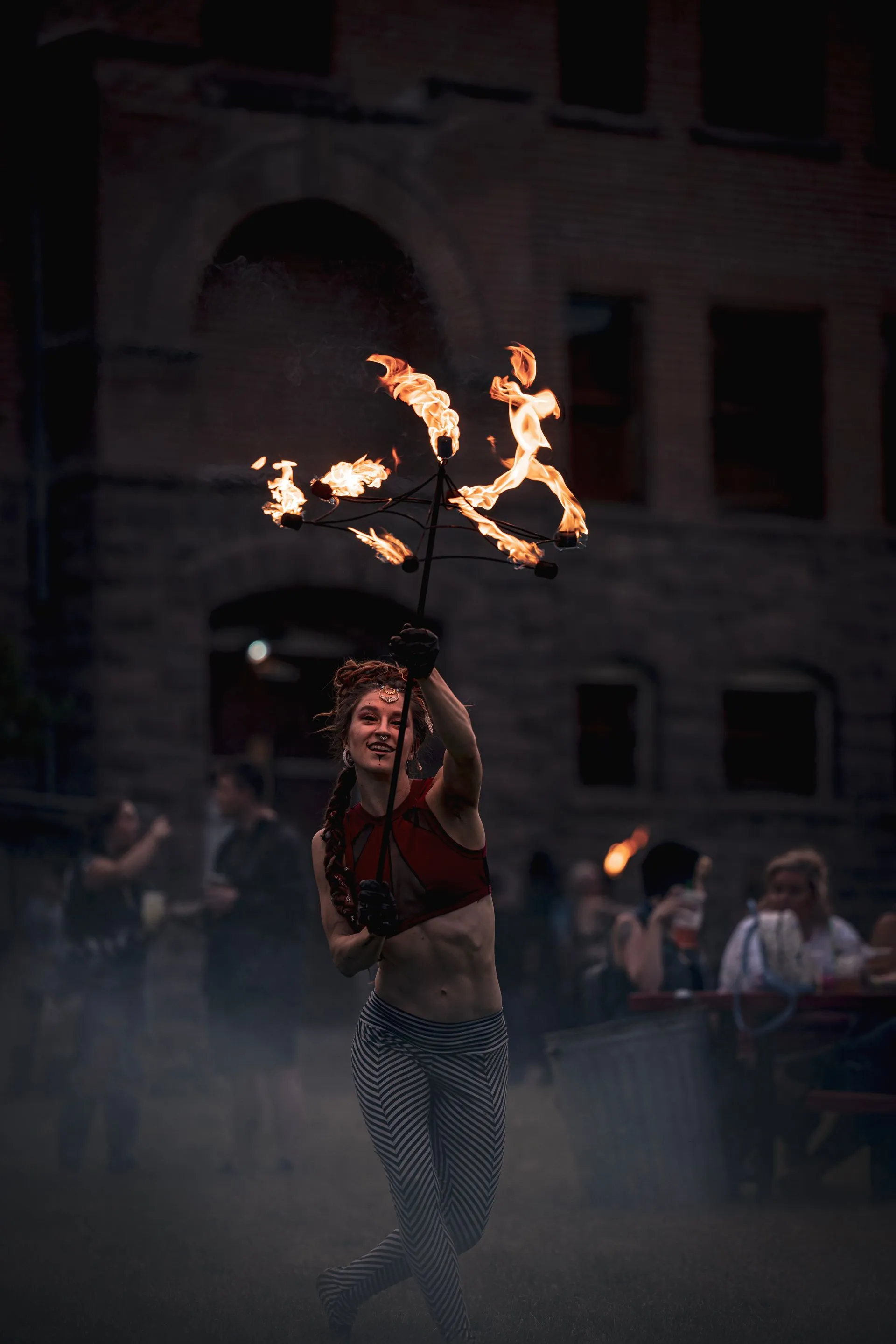 A woman is holding a torch with flames coming out of it.