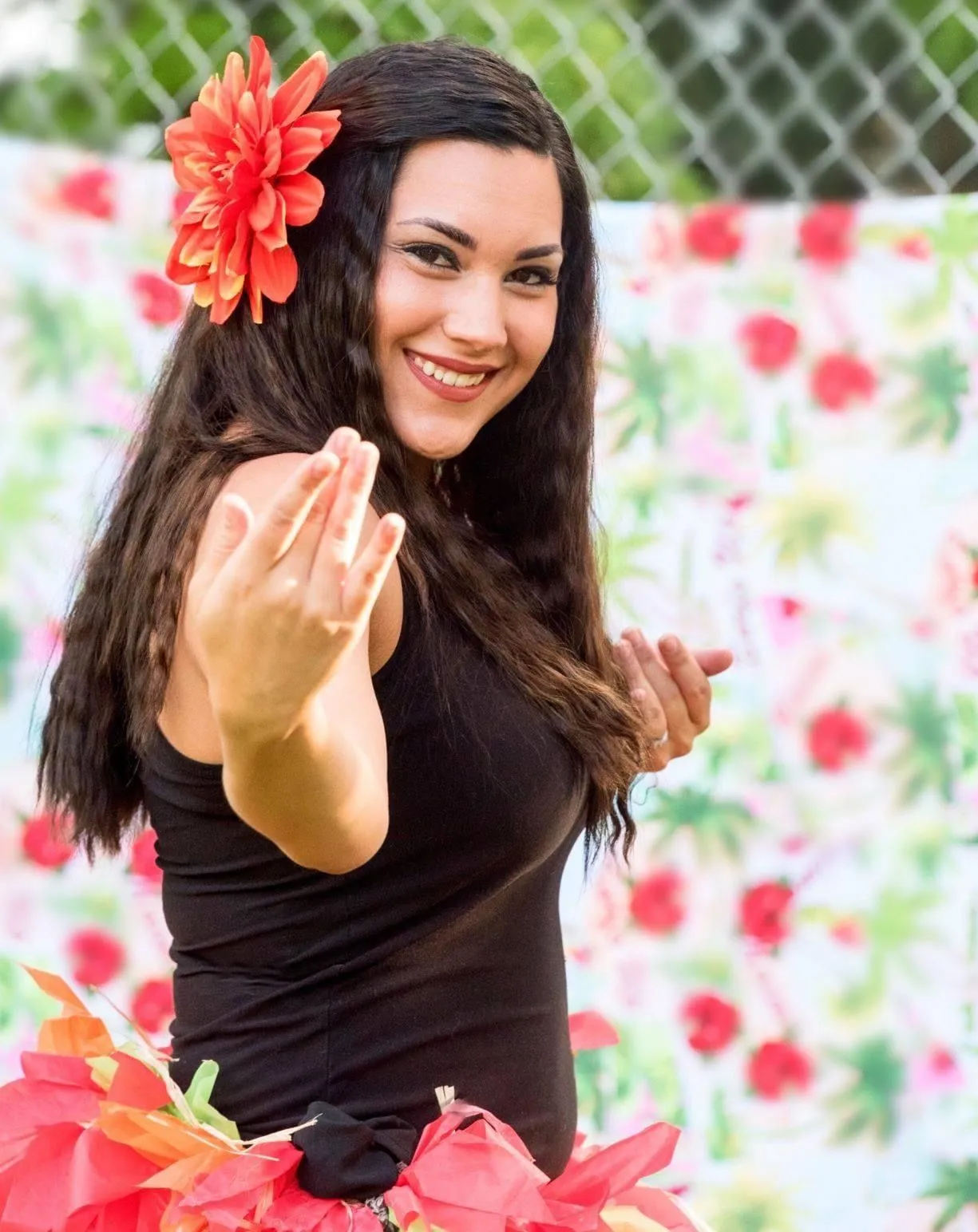 A woman with a flower in her hair is smiling