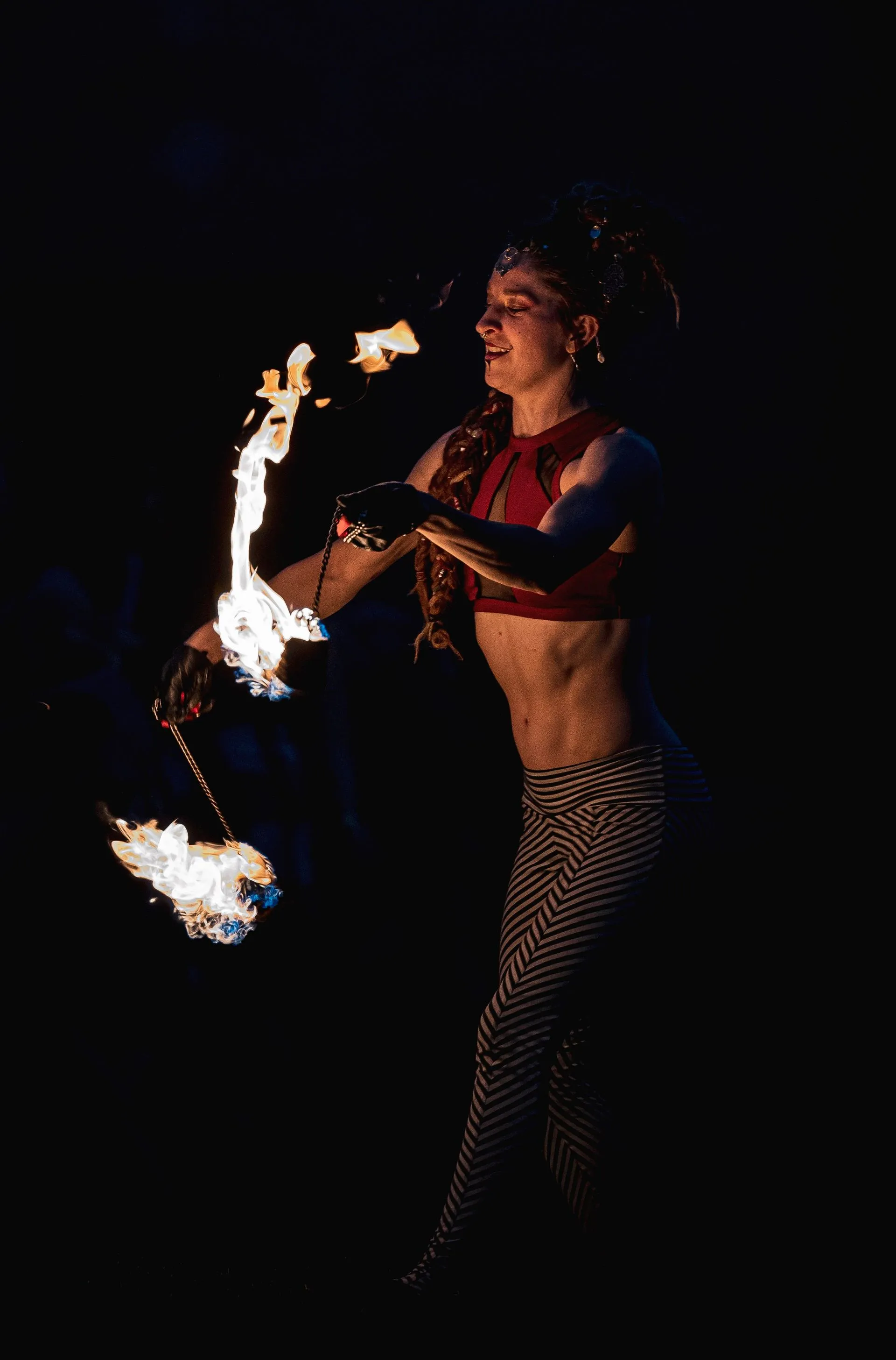 A woman is holding a torch in her hand in the dark.