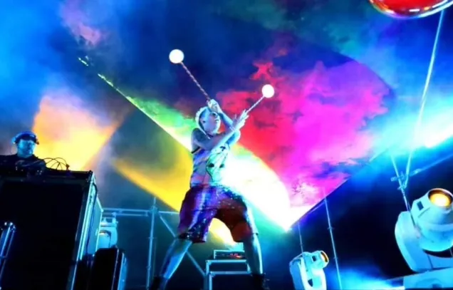 A woman performing with LED poi at a rave.