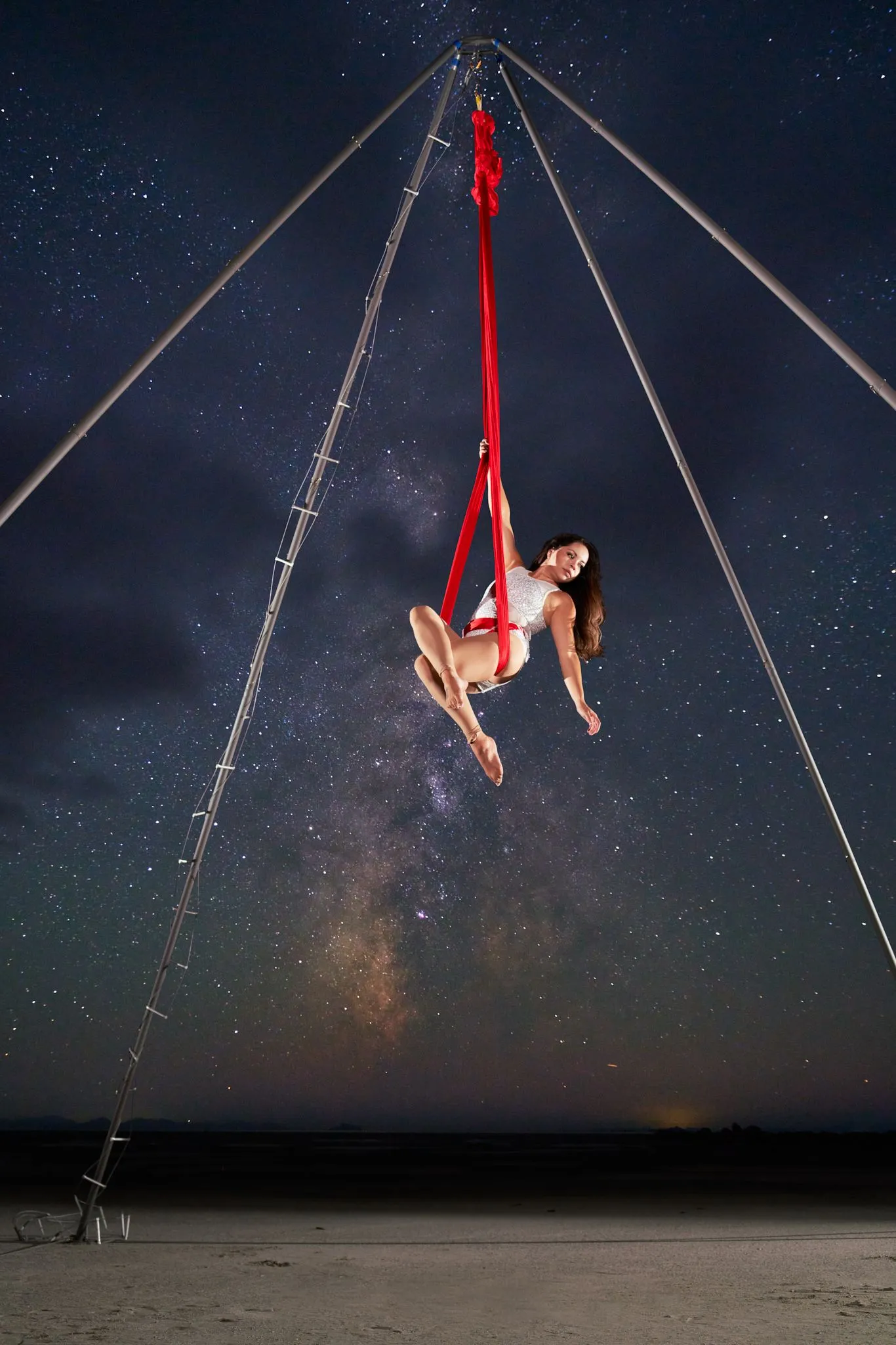 A woman performing aerial hammock outside.