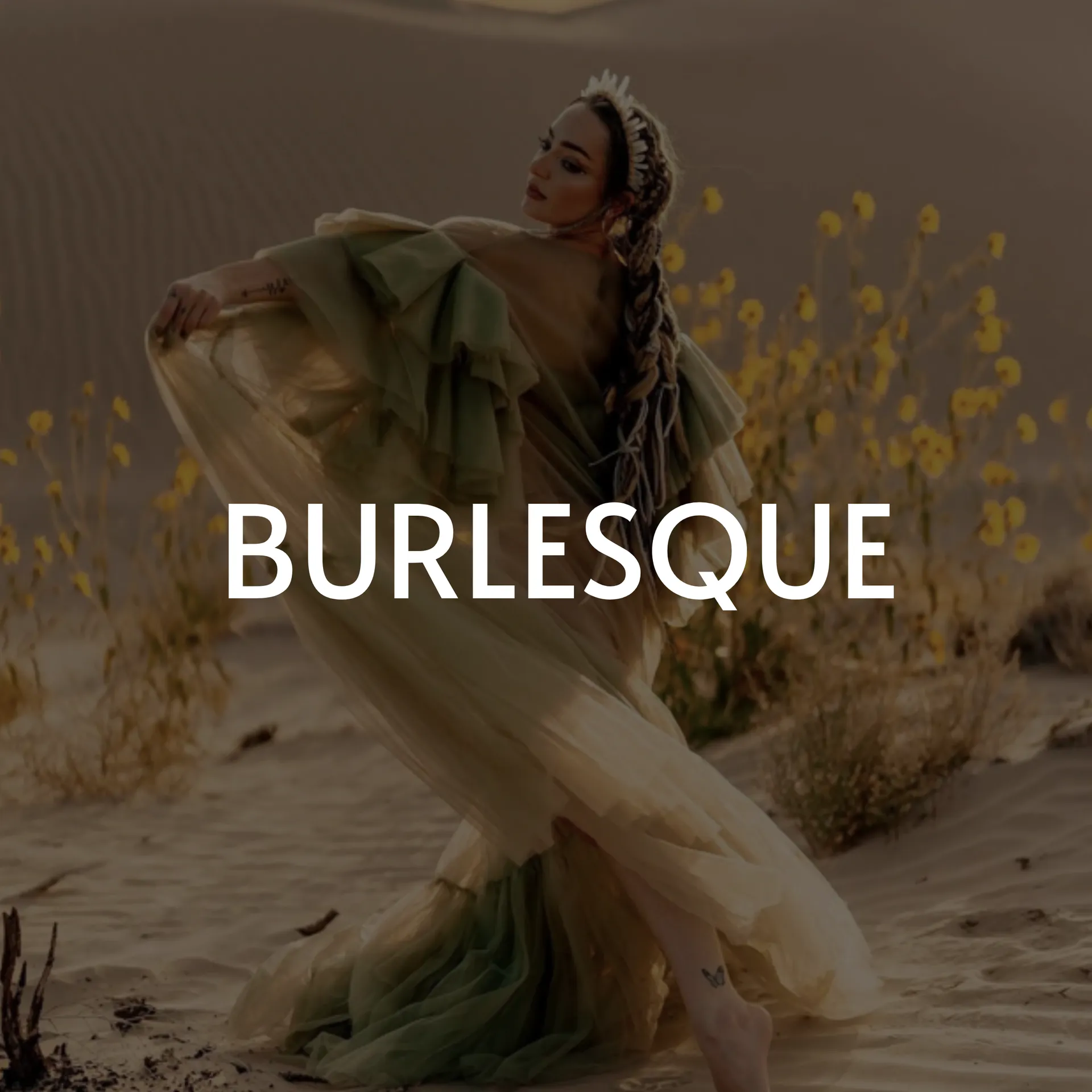 Woman in flowing green dress, a crown, and long braid dances in a desert, “Burlesque” text overlay.