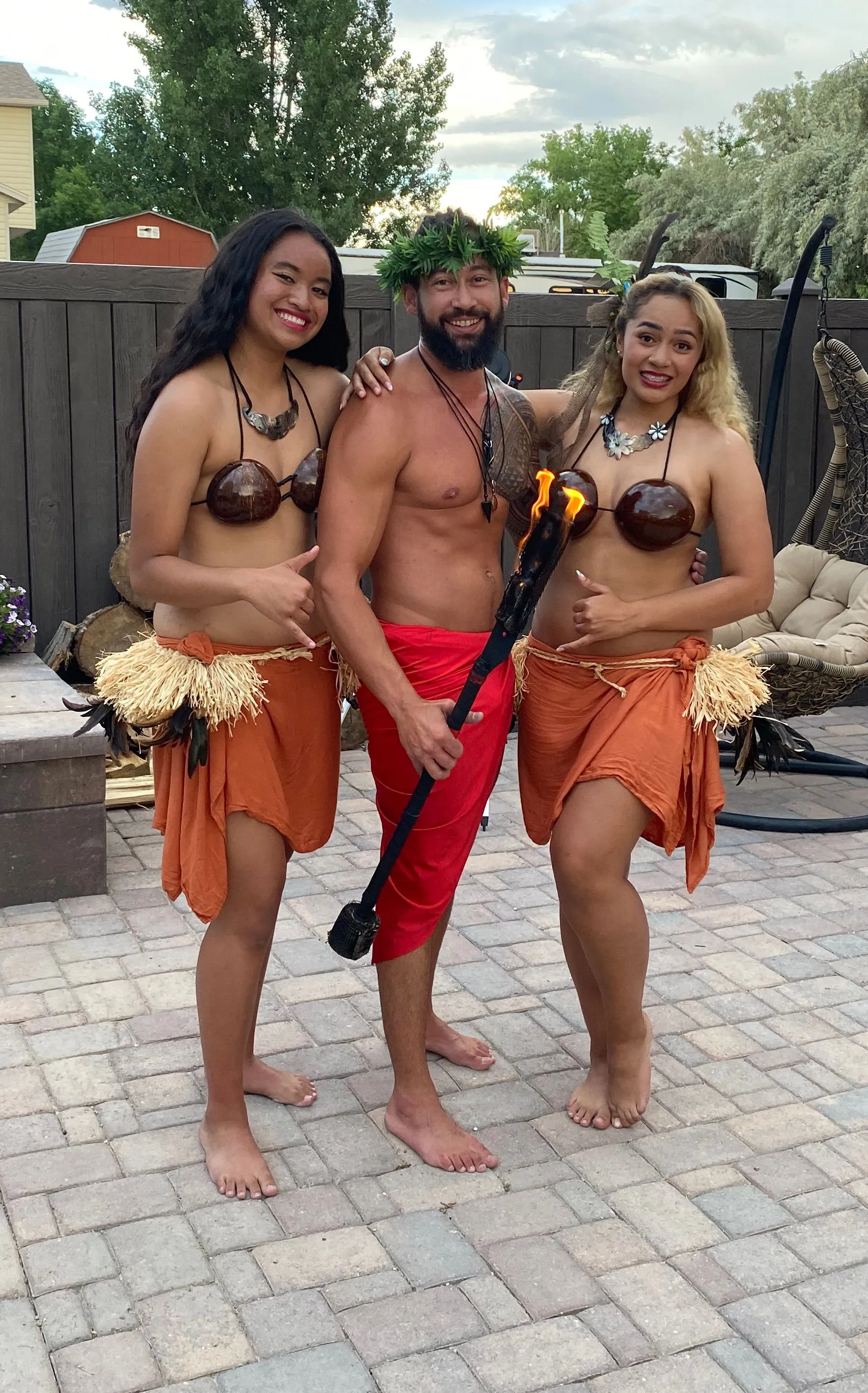 A man and two women are posing for a picture on a patio.