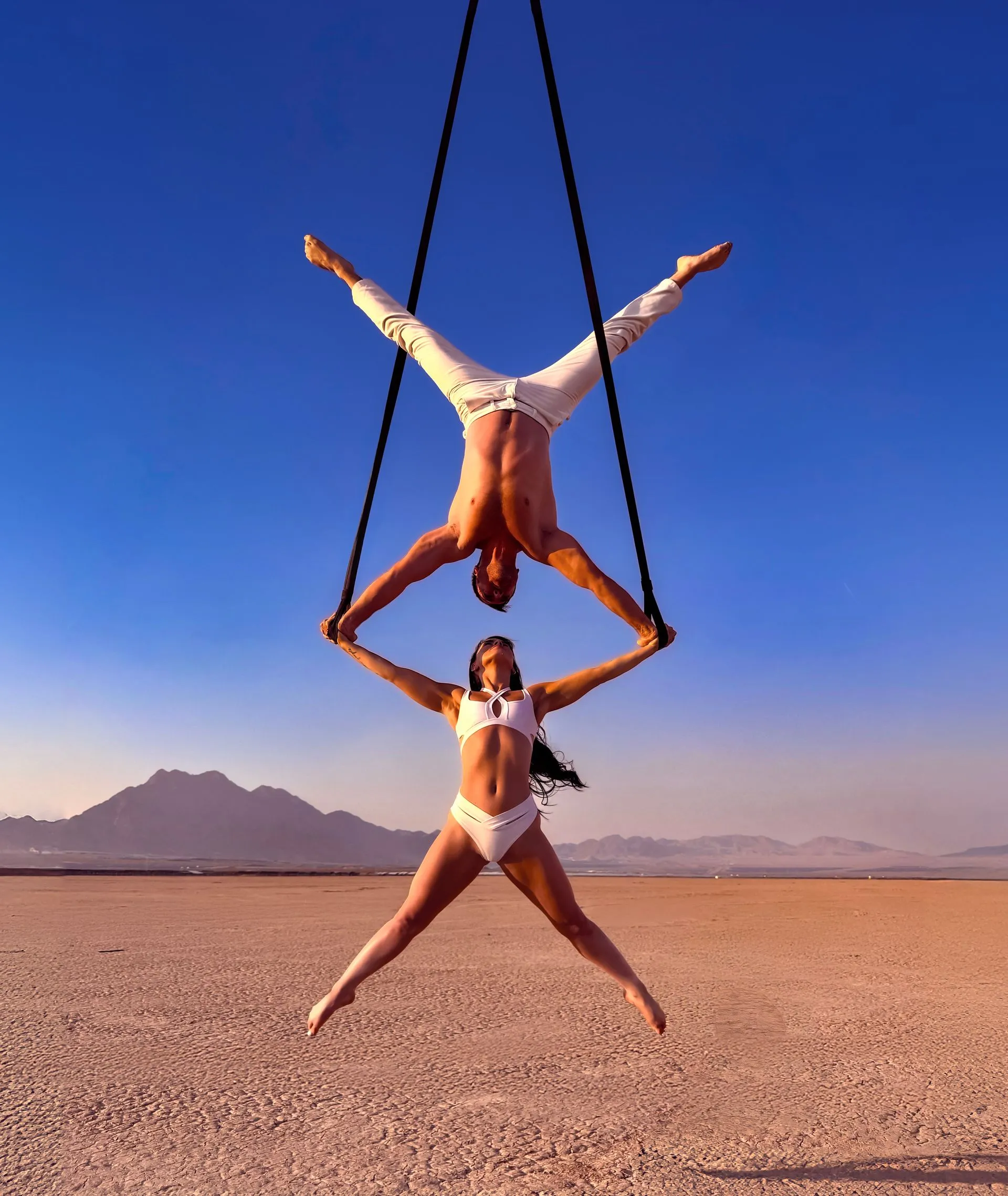 A man and a woman are hanging upside down in the air