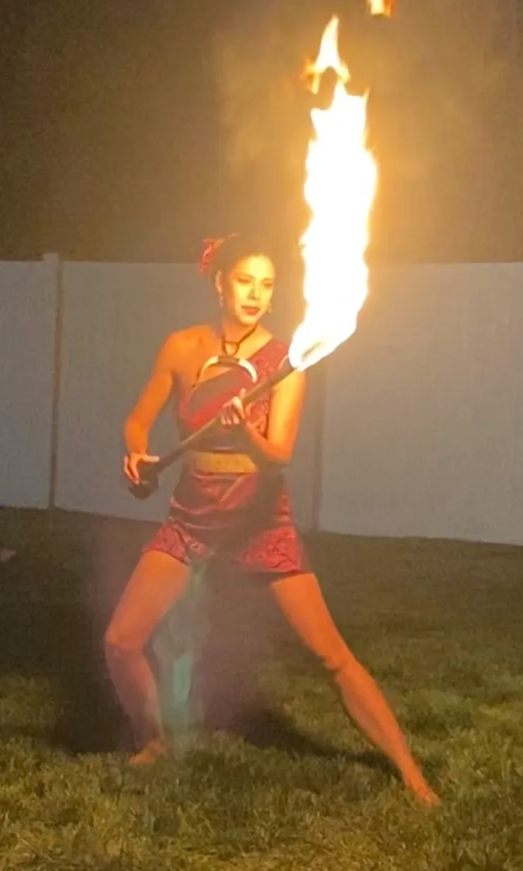 A woman is holding a torch with flames coming out of it