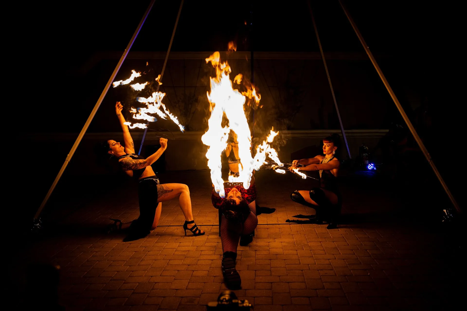 A group of people are performing a fire show at night.