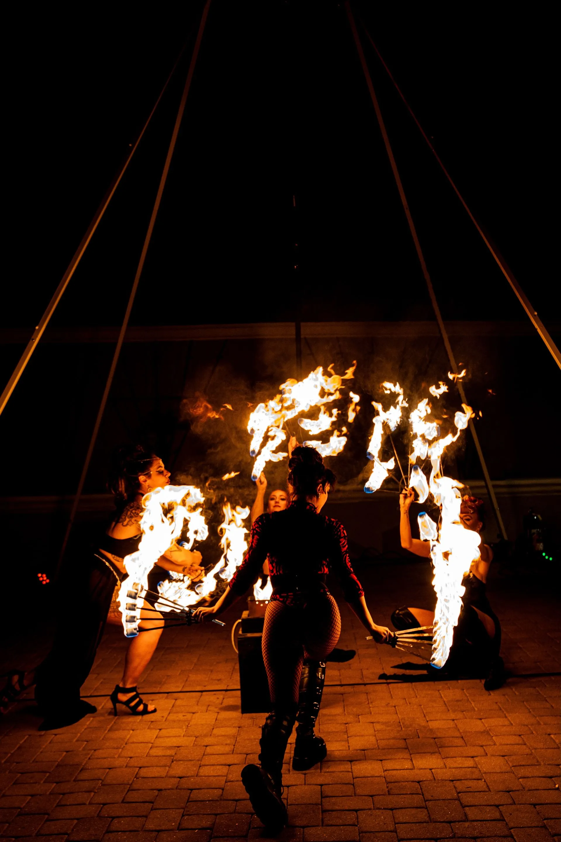 A group of people are performing a fire show at night.