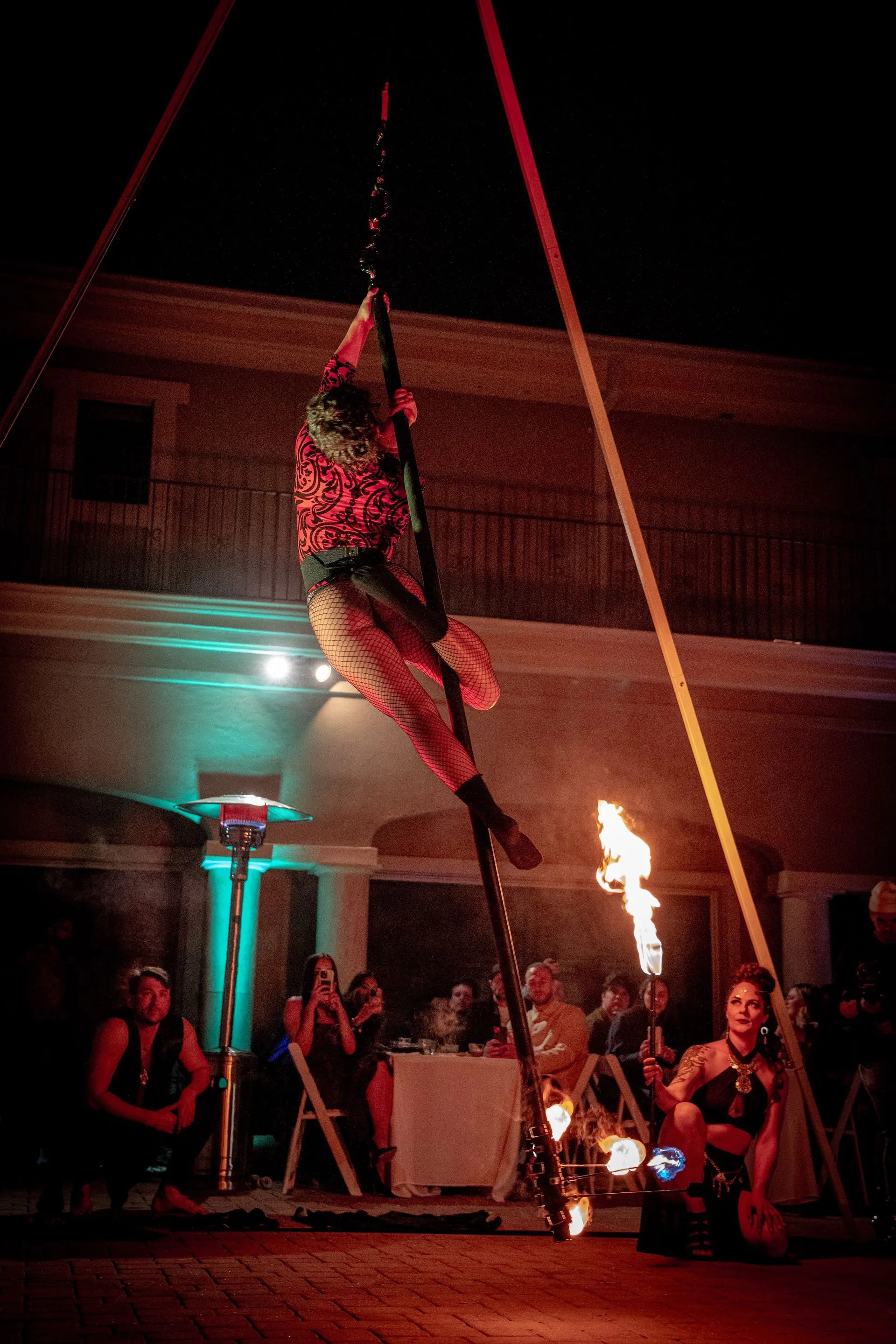 A woman performing on an aerial pole.