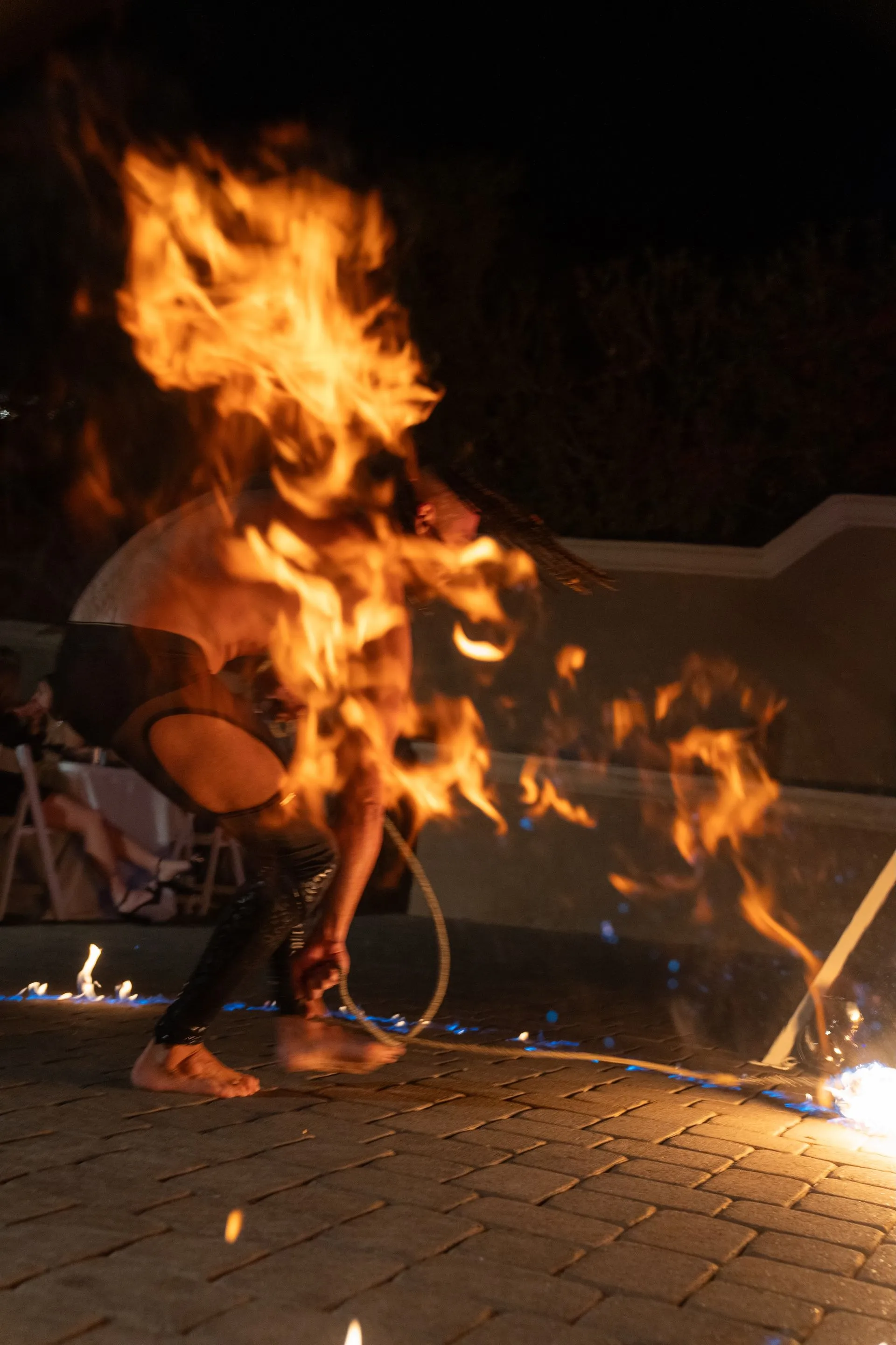 A man is holding a hoop with fire coming out of it.