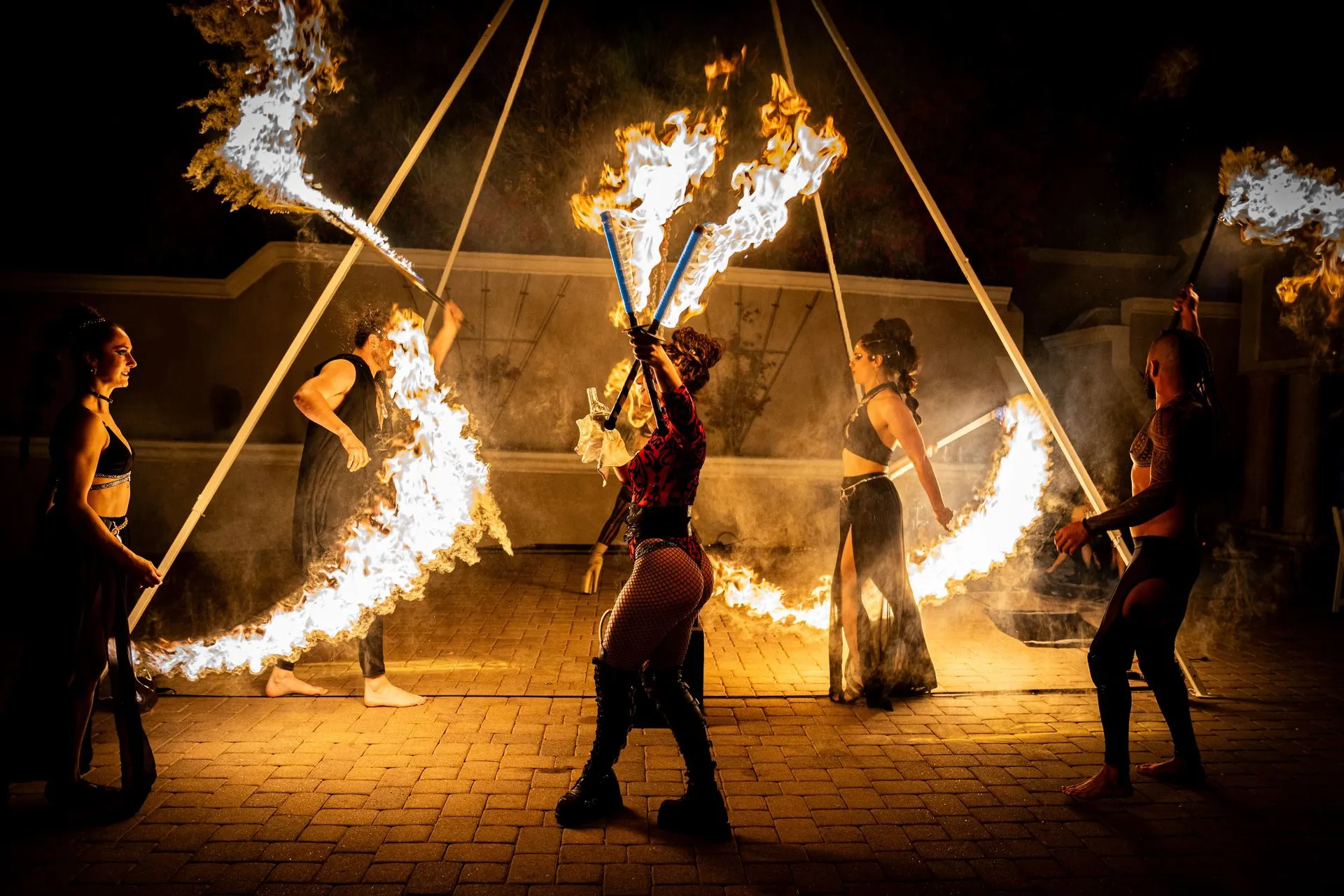 A group of people are performing a fire show at night.