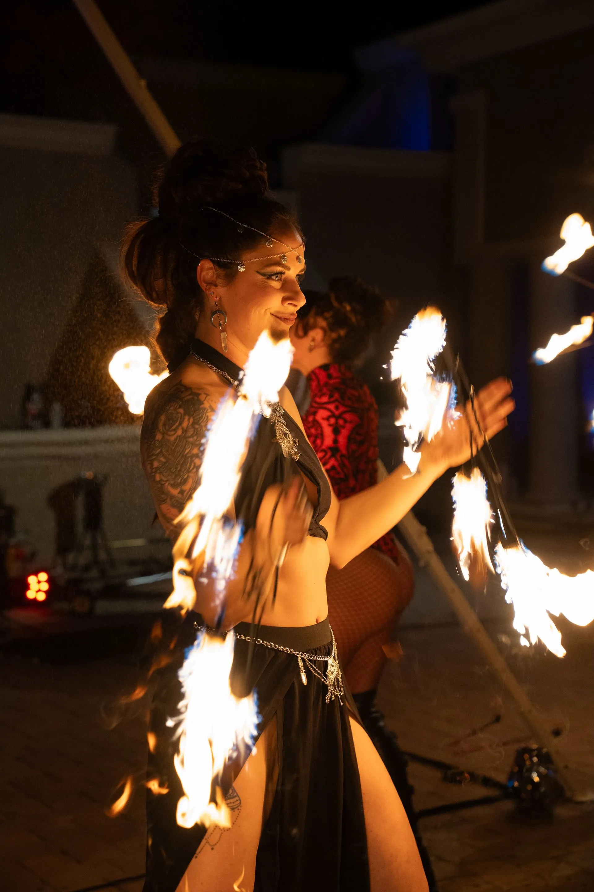 A woman is holding a stick of fire in her hand