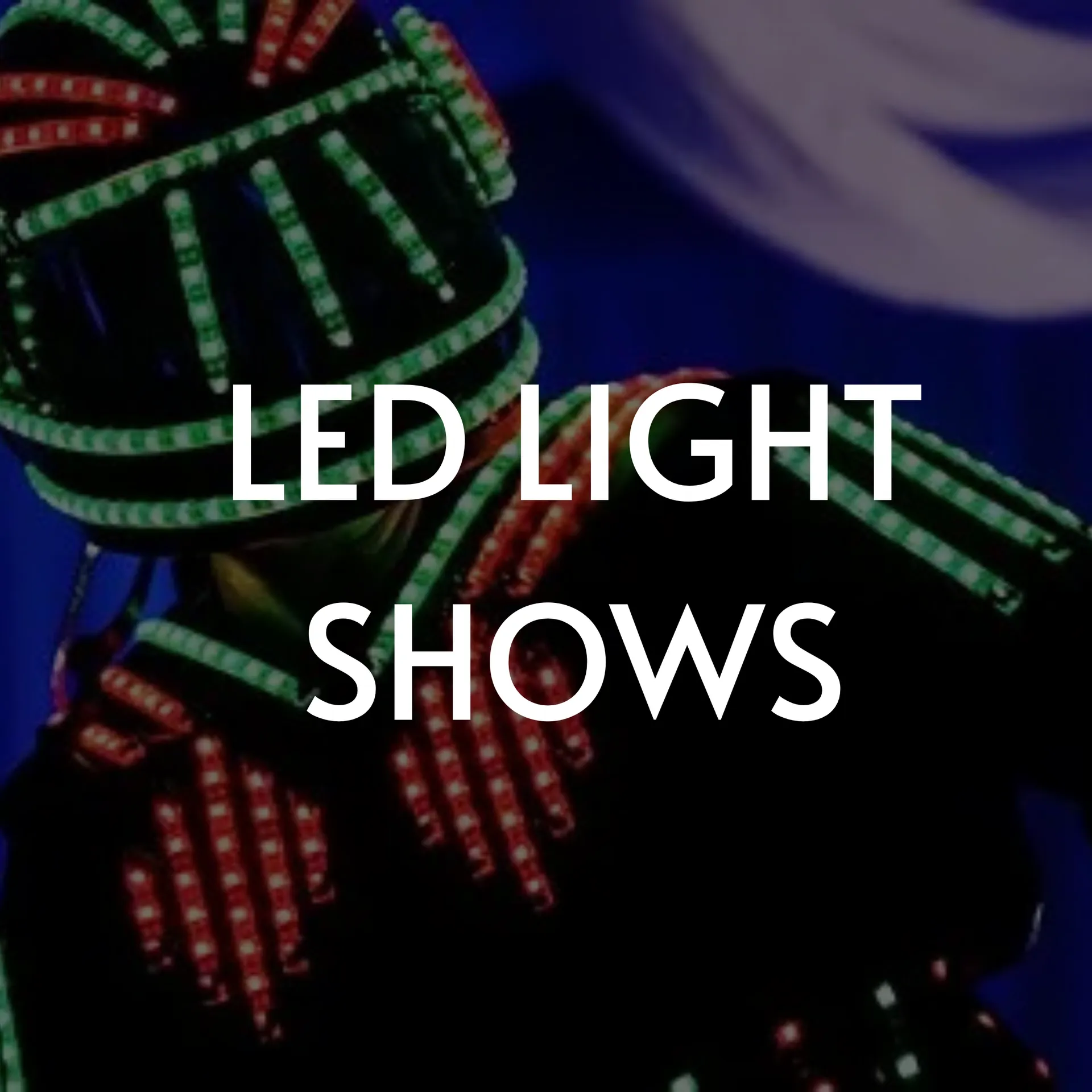 LED-lit performer in dark suit, red and green lights. Text 