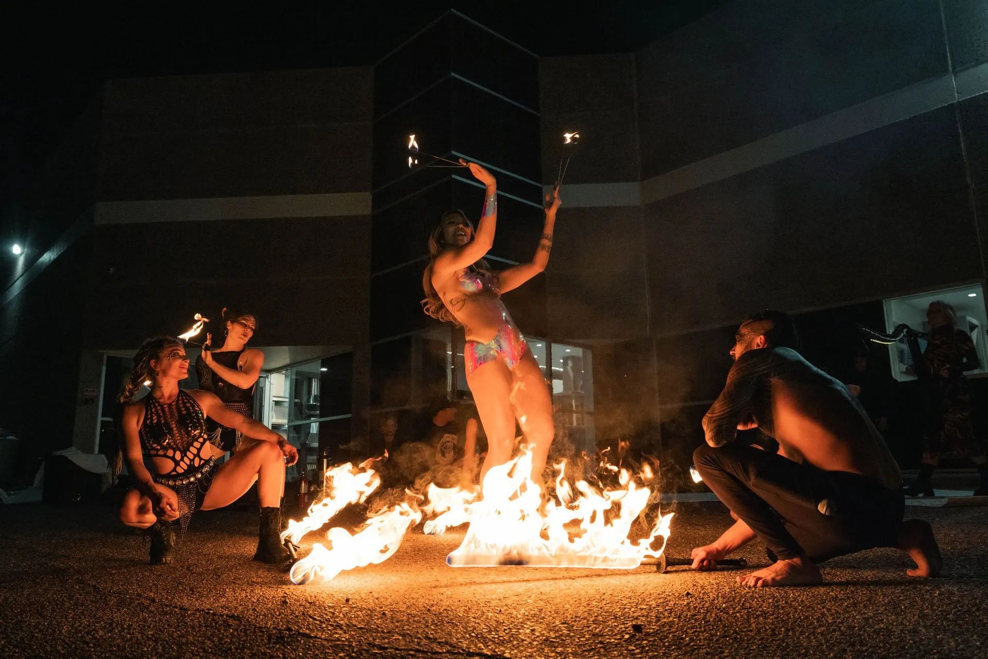 A group of people are standing around a fire at night.