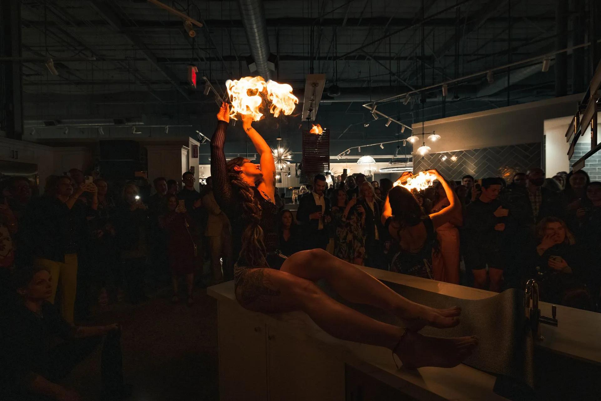 A woman is holding a torch in front of a crowd of people.