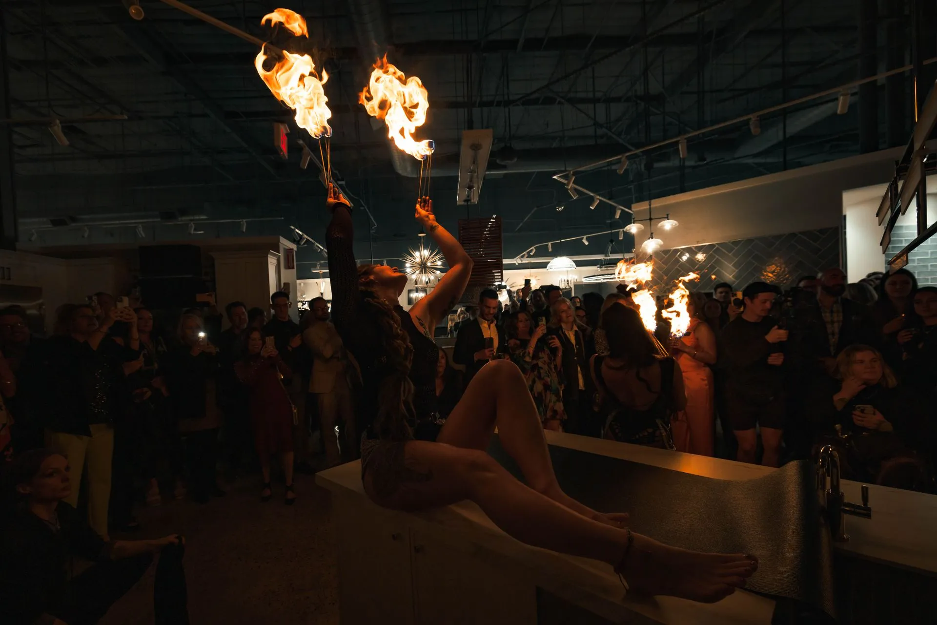 A woman on a counter top performing with fire.