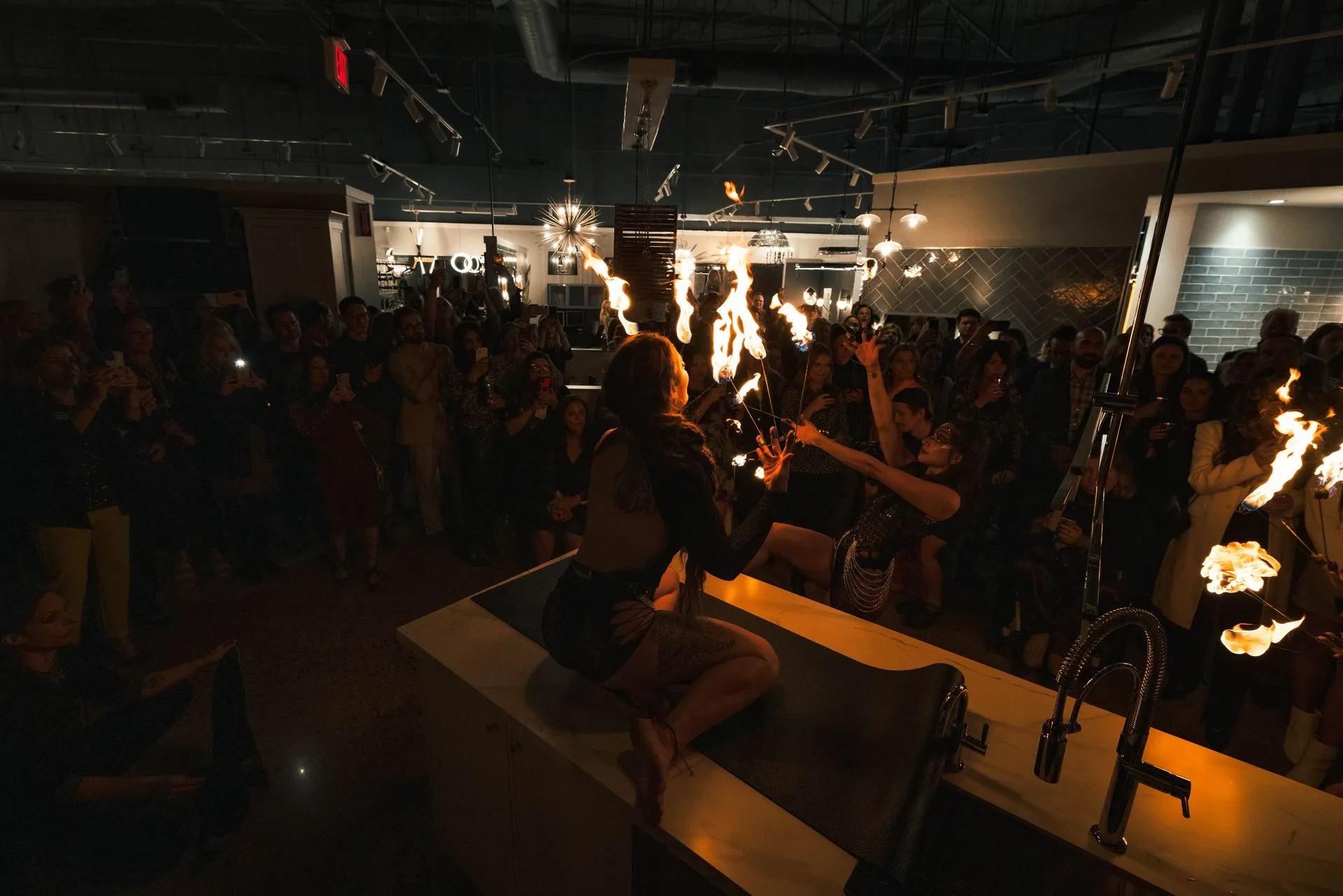 A woman is holding a torch in front of a crowd of people.