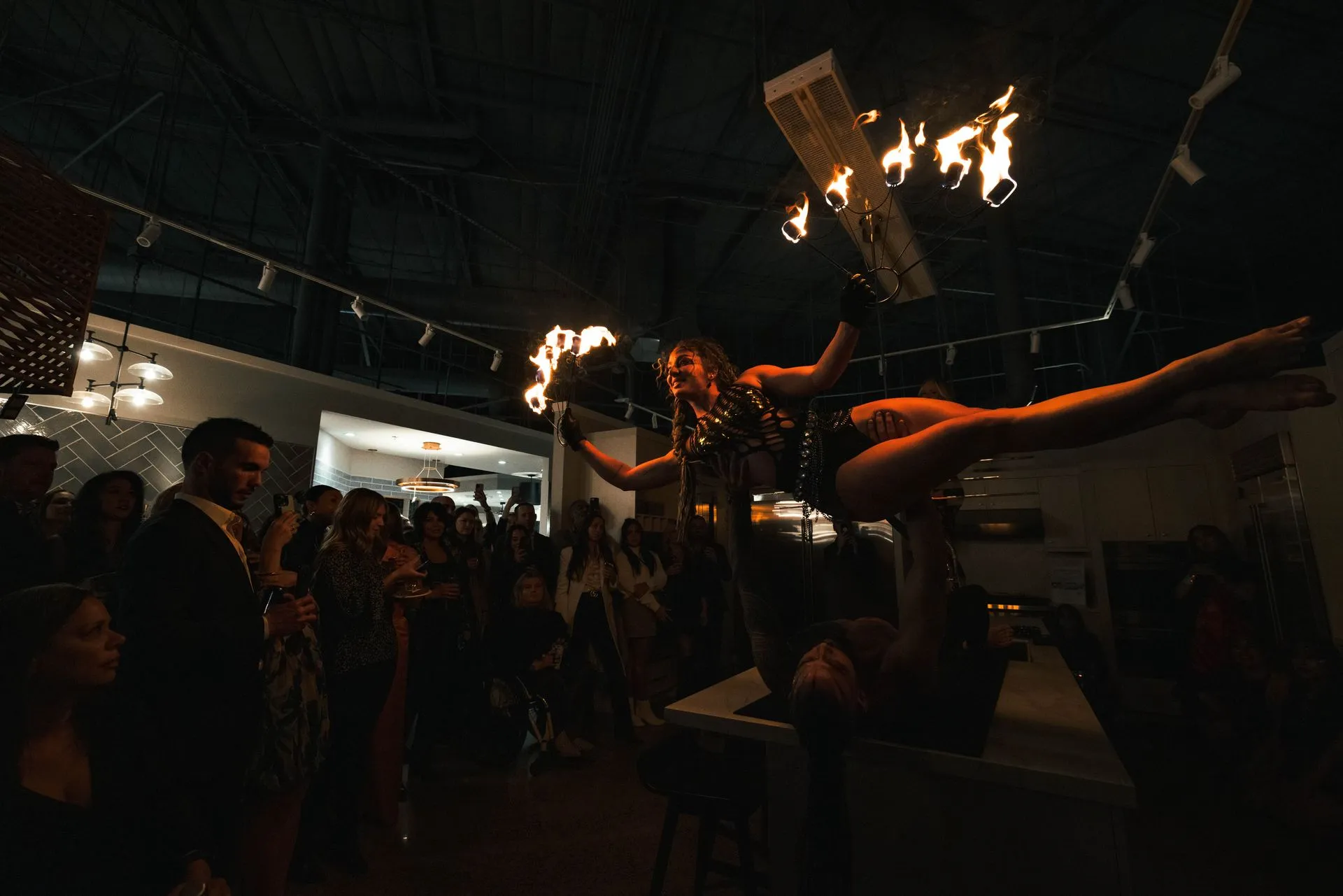 A woman is performing aerial acrobatics in front of a crowd of people.