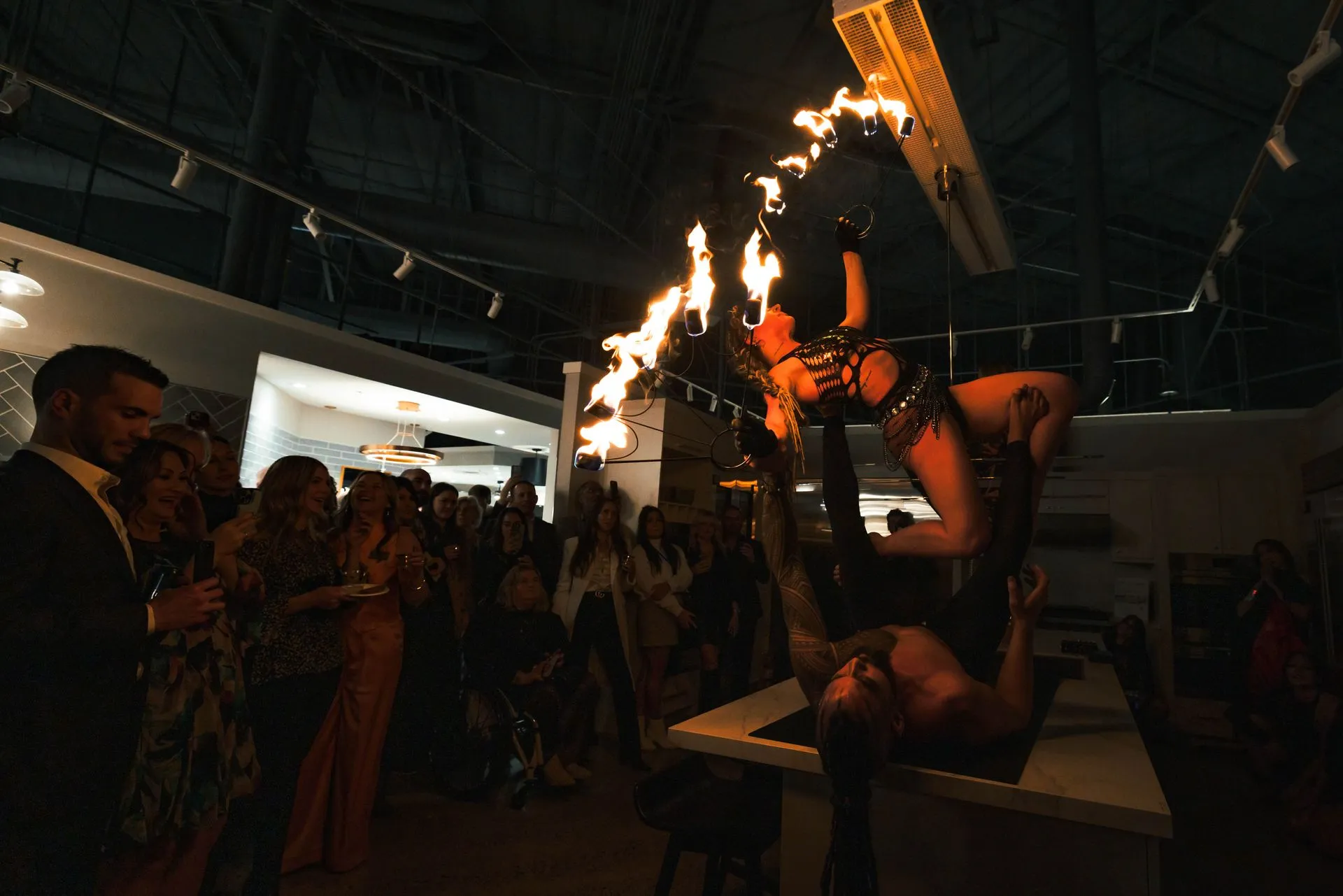 A woman is performing a fire show in front of a crowd of people.