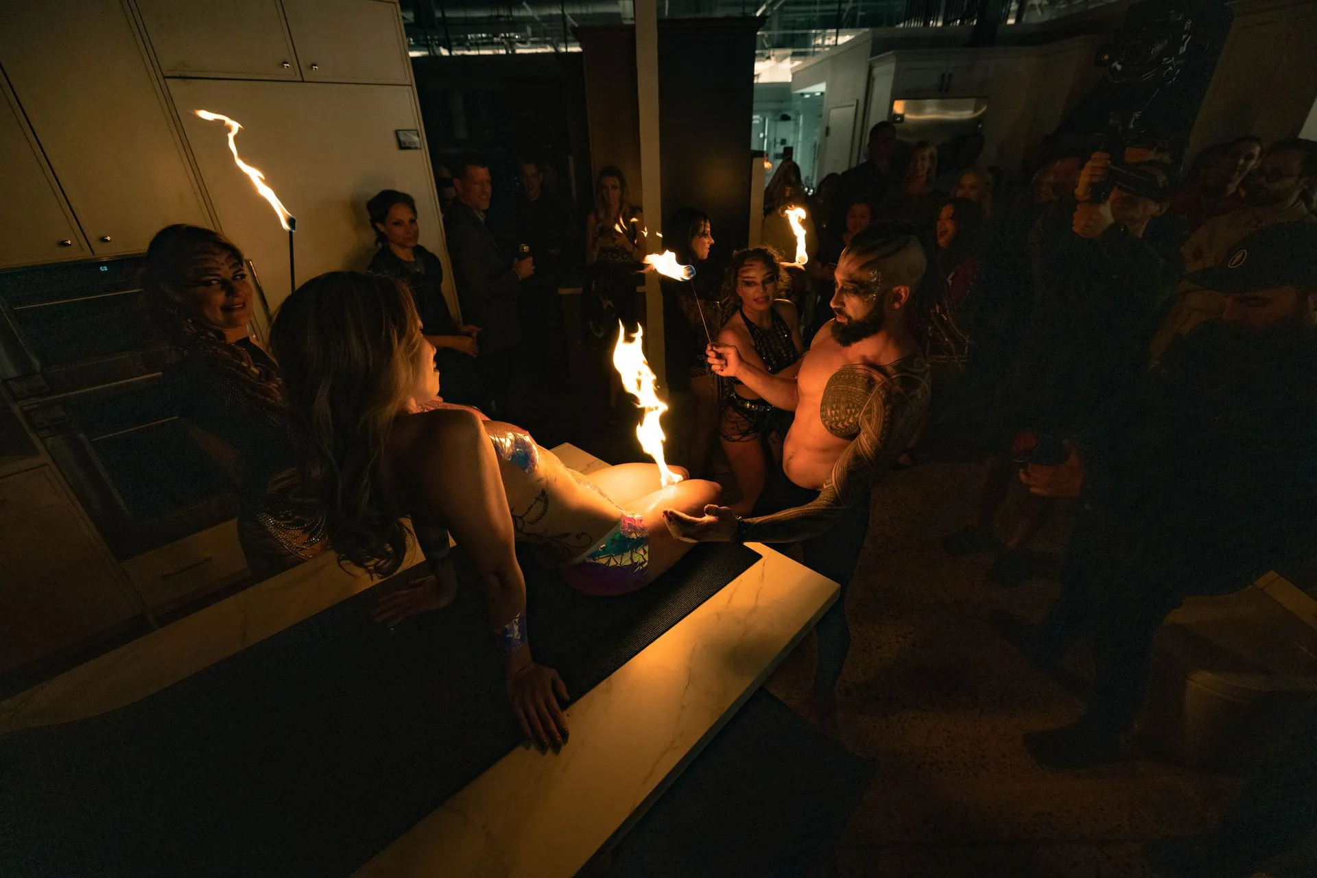 A group of people are watching a woman perform a fire show.