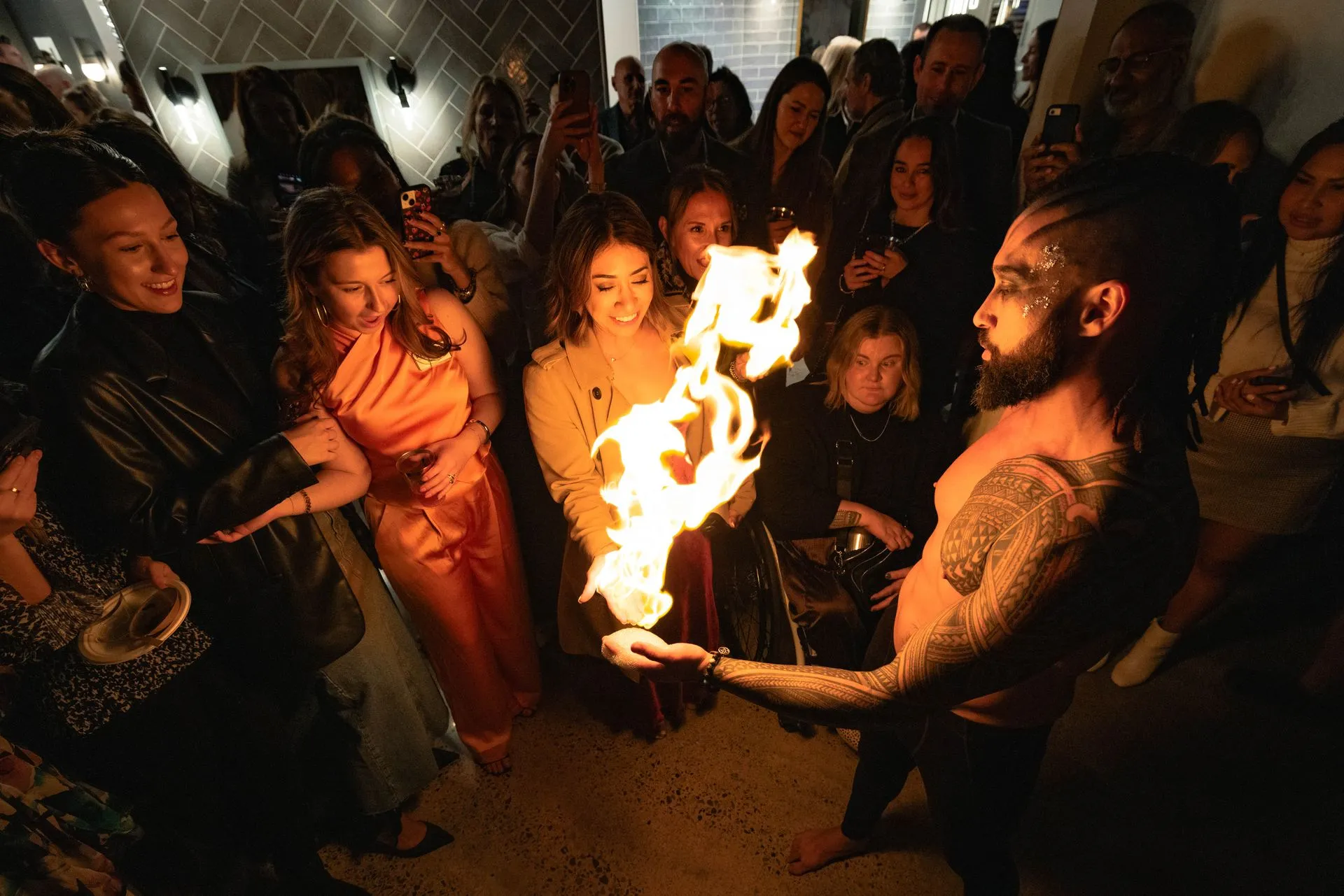 A man is holding a torch in front of a crowd of people.
