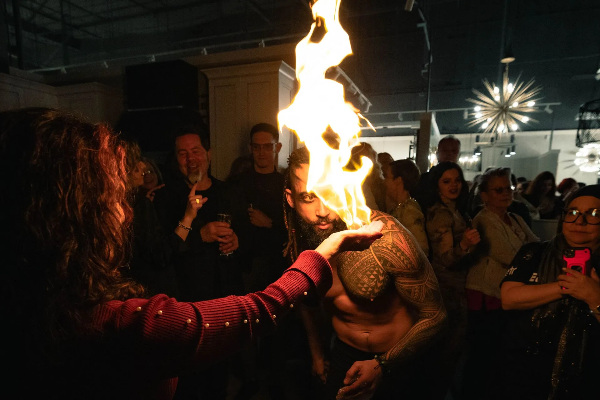 A woman is holding a torch in front of a crowd of people.