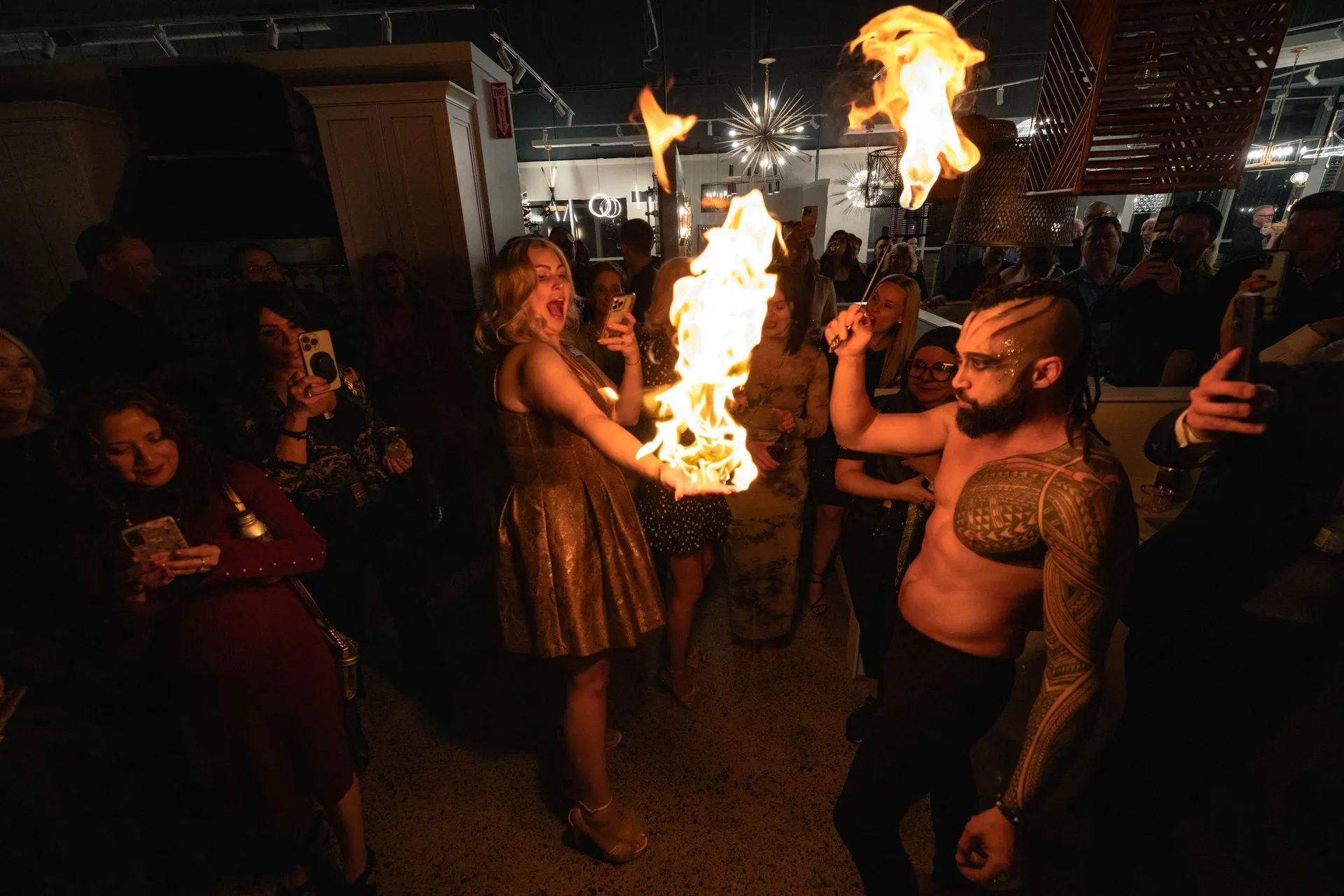 A man and a woman are holding a fire torch in front of a crowd of people.