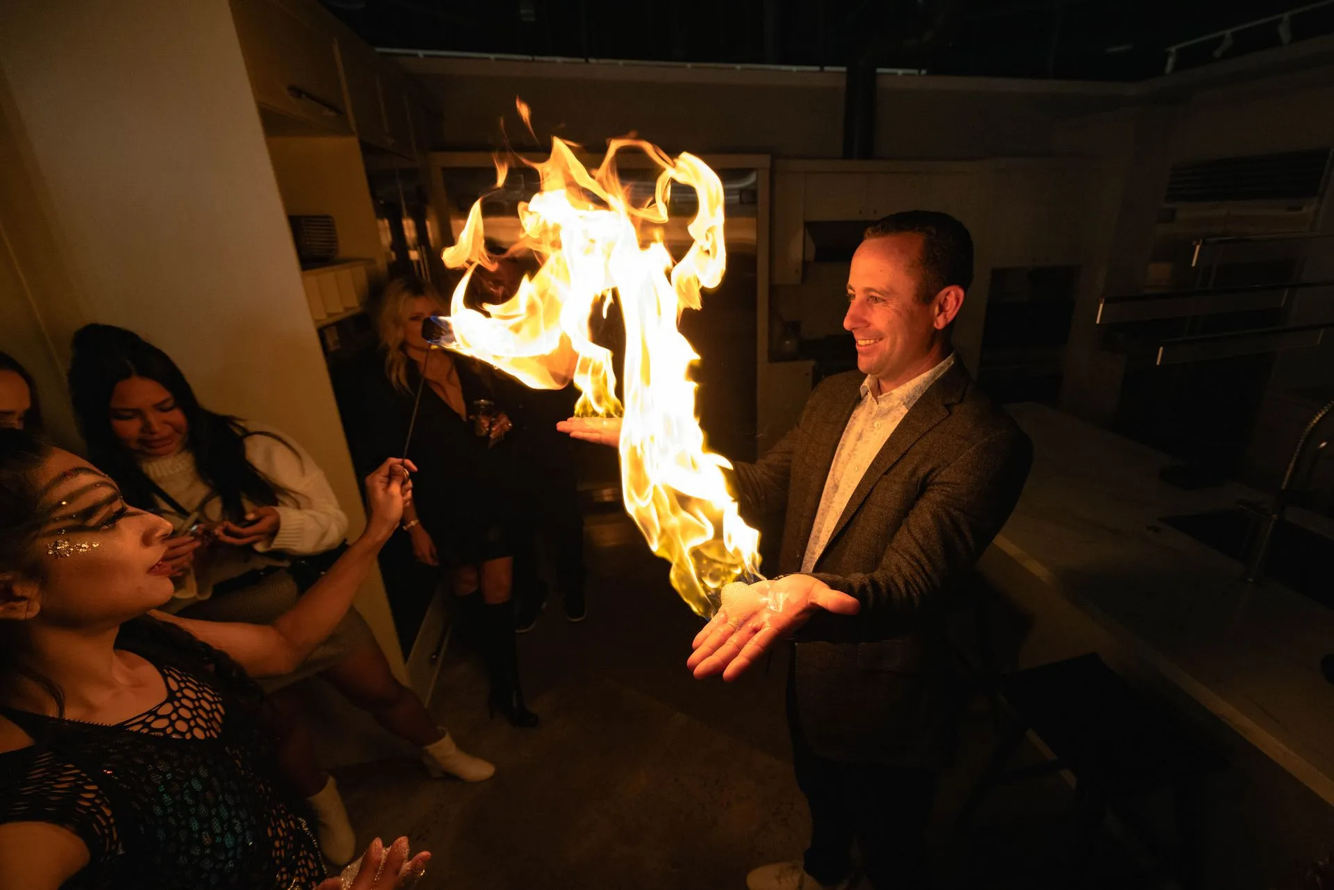 A man in a suit is holding a fireball in his hand.
