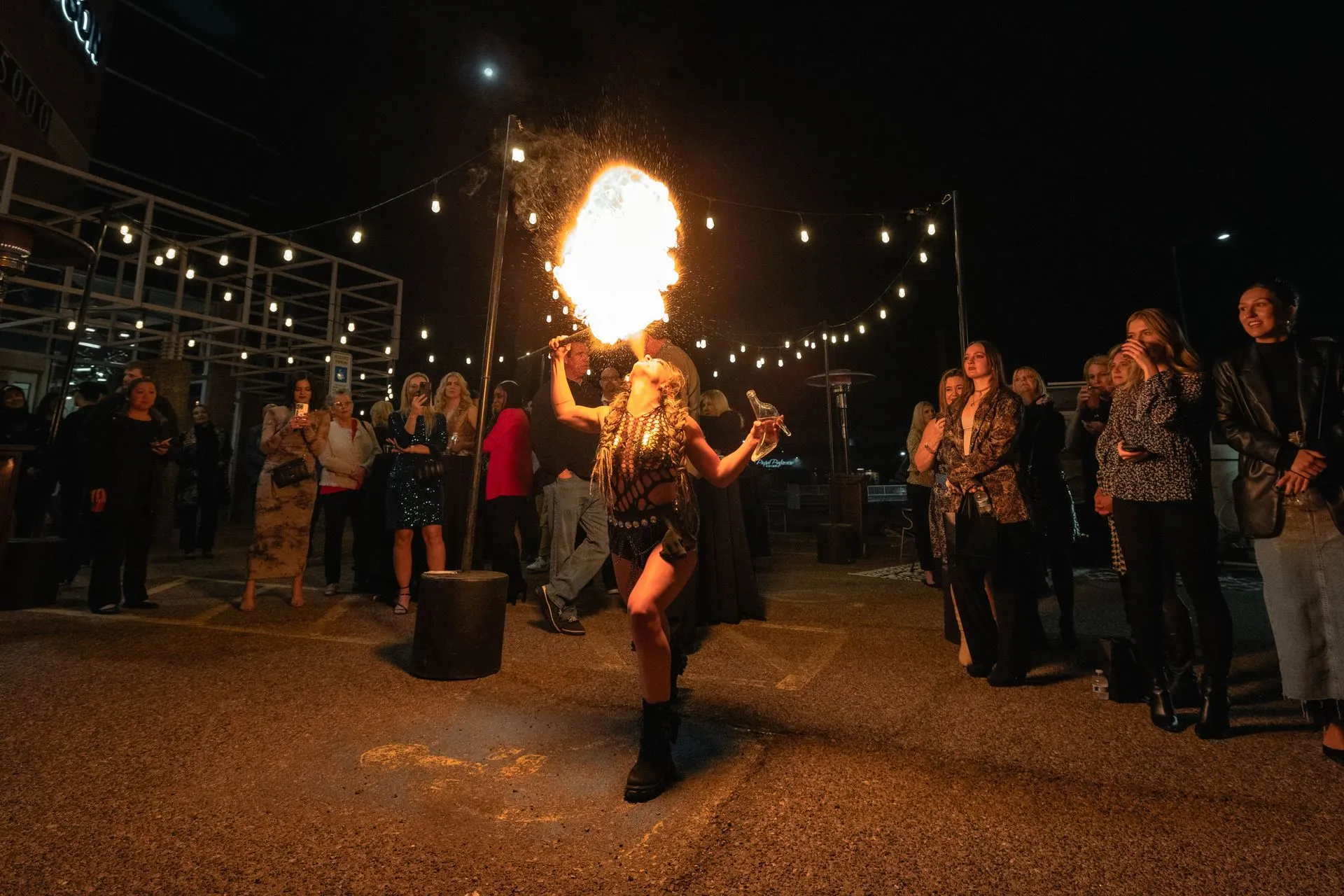 A woman is holding a torch with flames coming out of it.