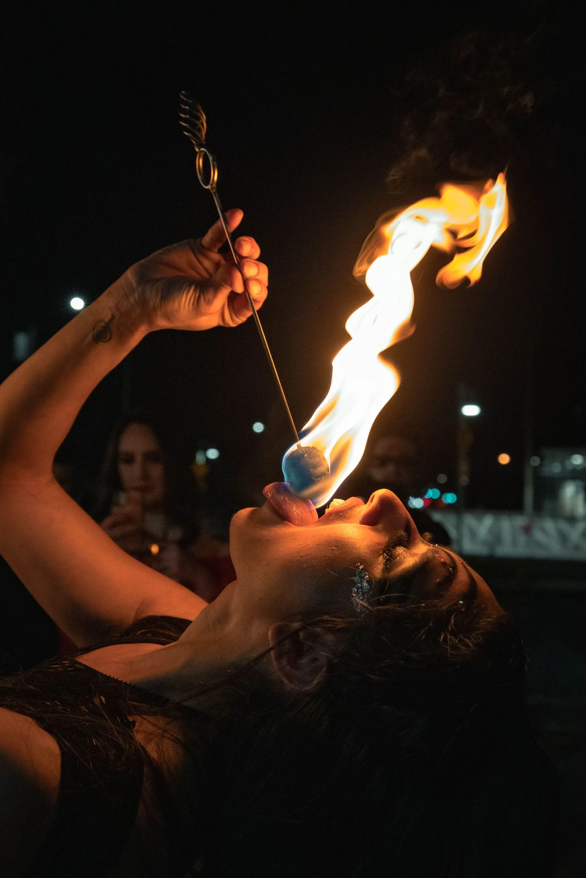 A woman is blowing fire out of her mouth.
