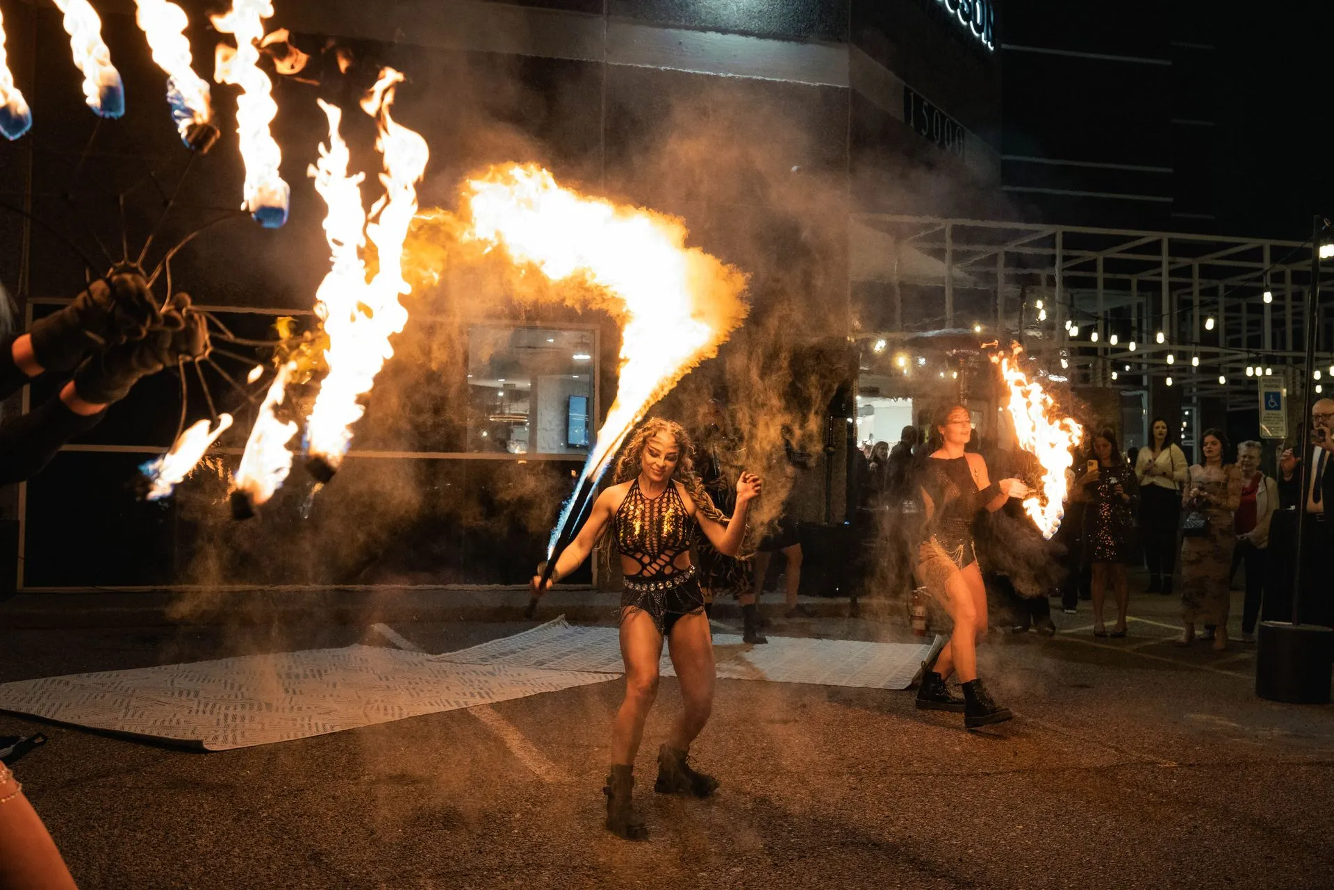 A woman is holding a torch with flames coming out of it.