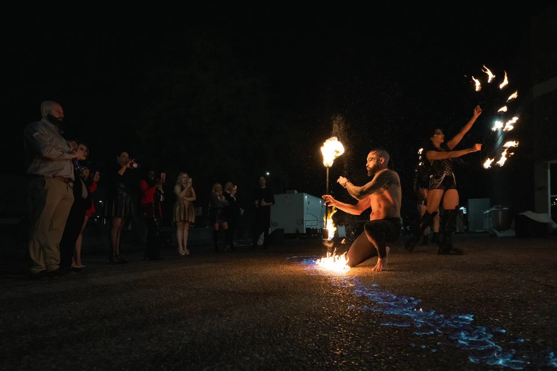 A man and a woman are performing a fire show at night.