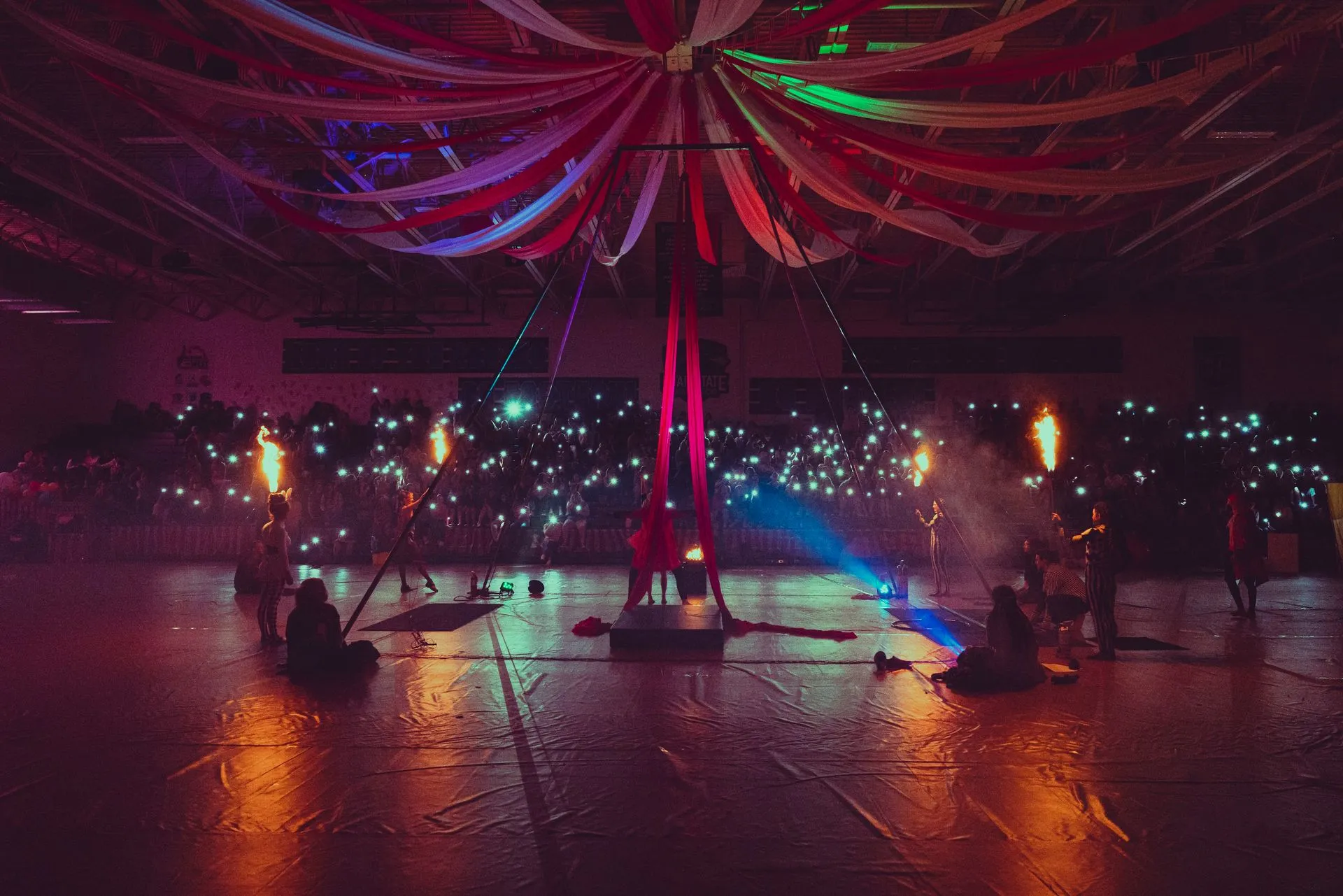 A group of people are standing on a stage in a dark room.