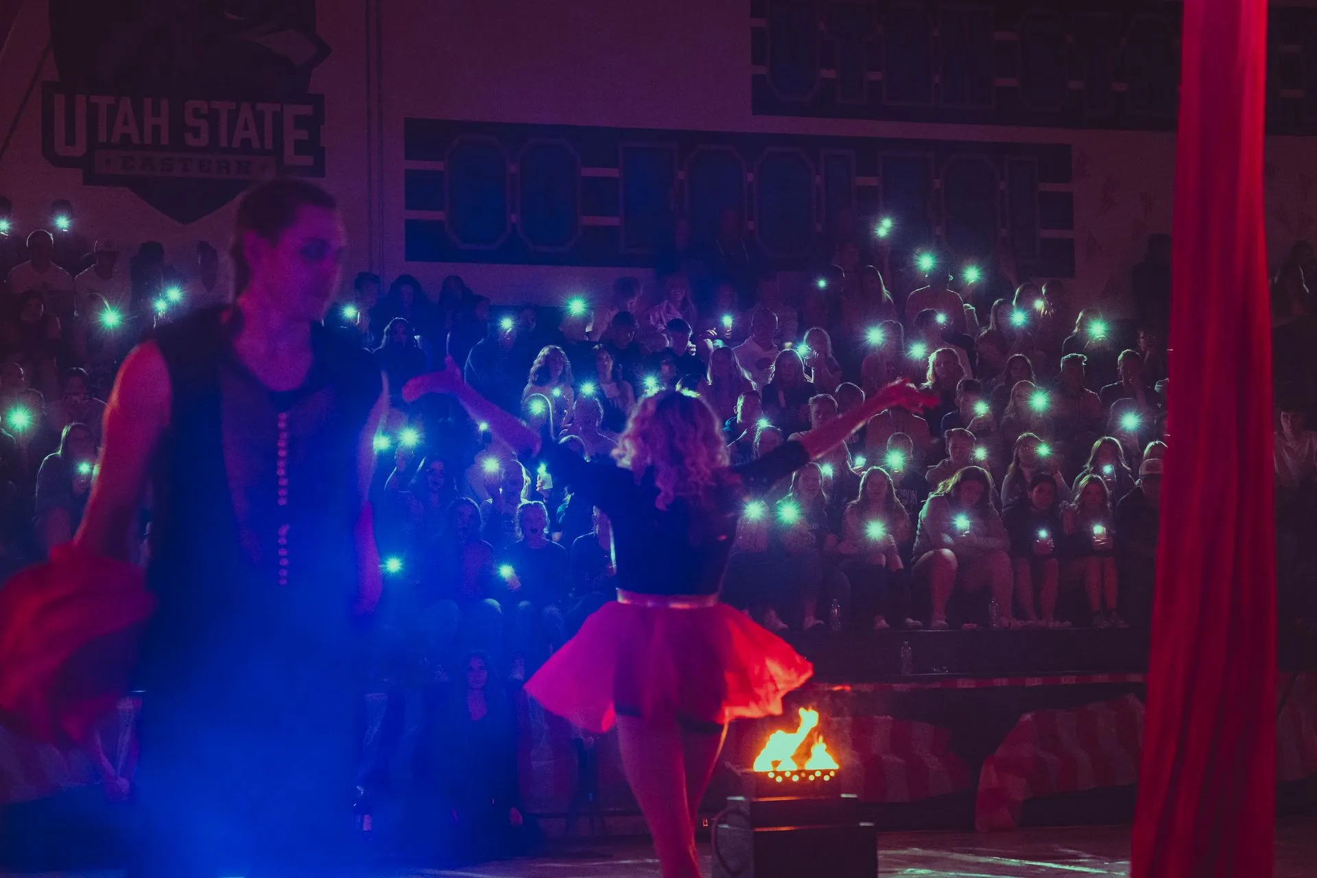 A man and a woman are dancing on a stage in front of a crowd.