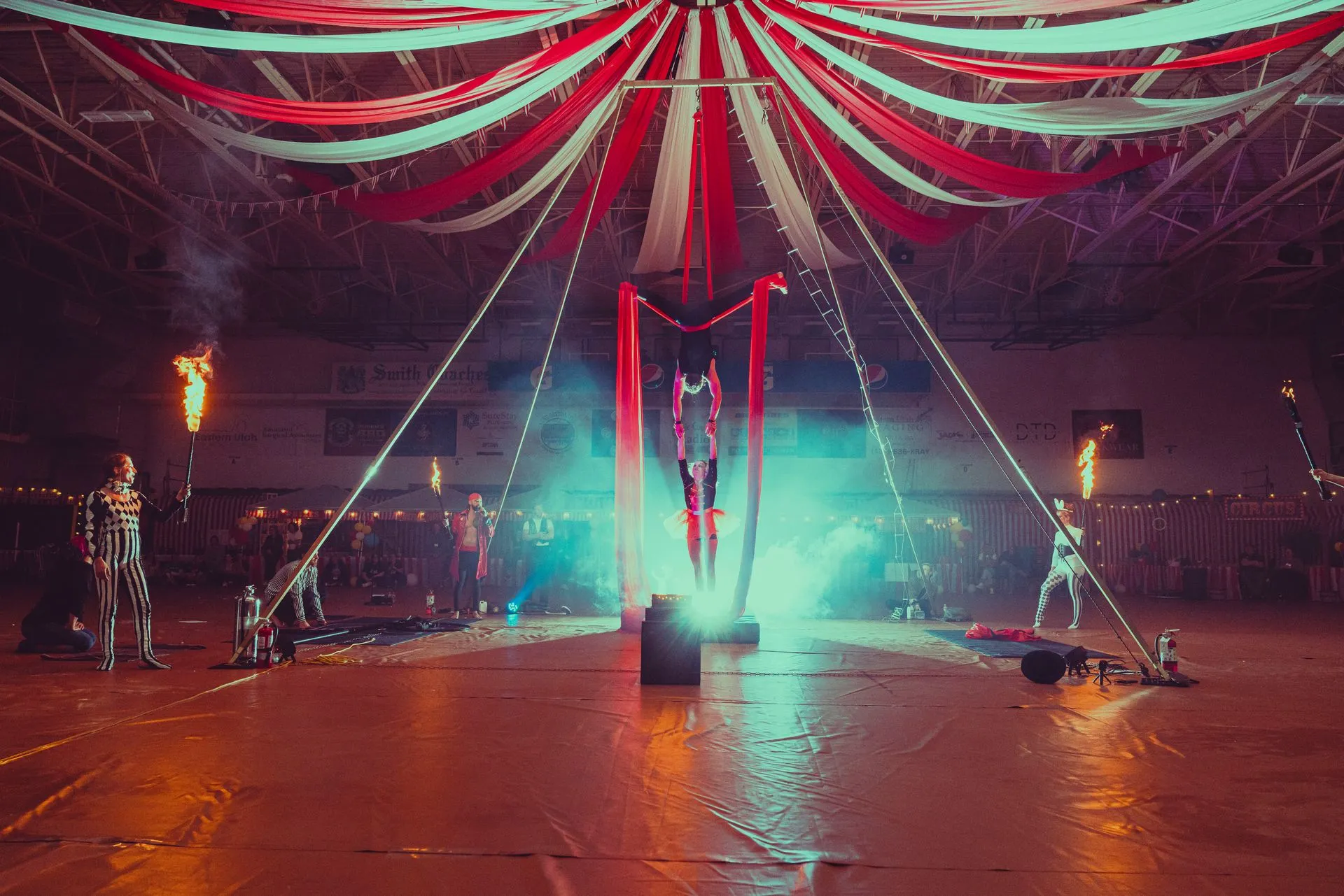 A circus act is being performed in a large indoor arena.