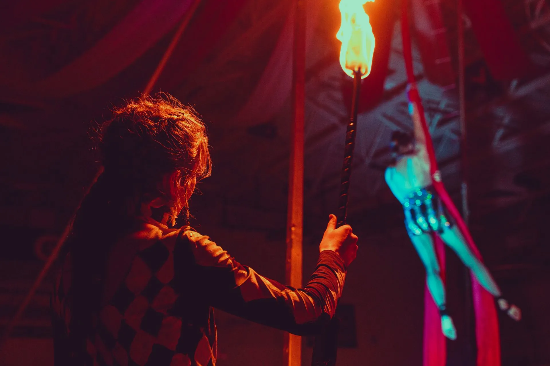 A man is holding a torch in front of a woman flying through the air.