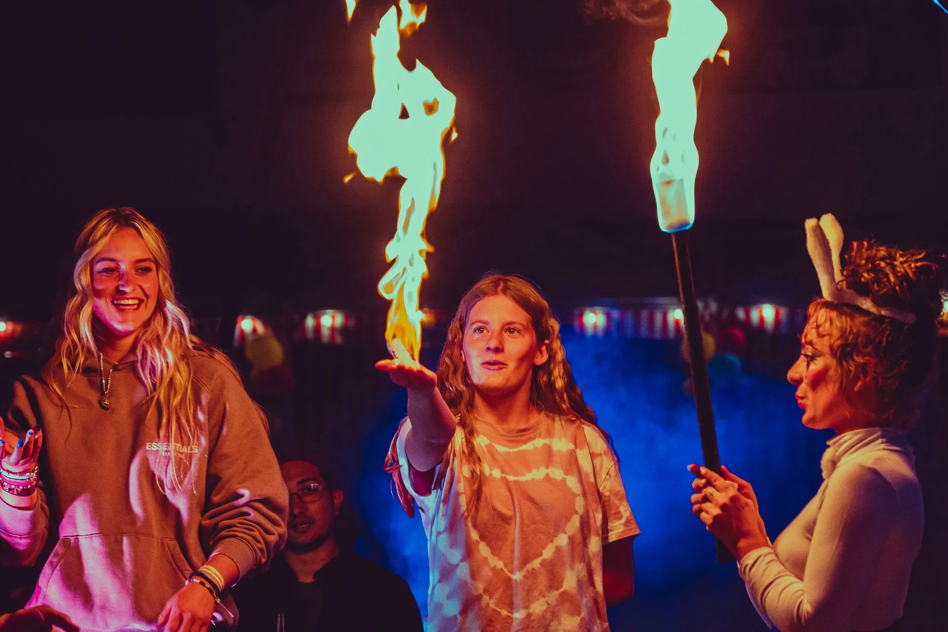 A group of people are standing in front of a fire torch.