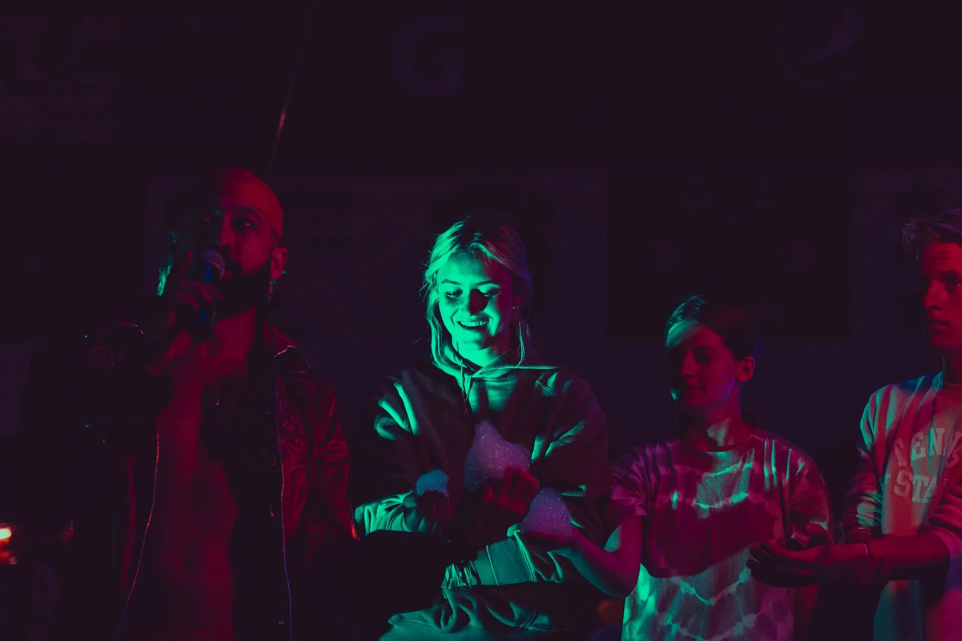 A group of people are standing next to each other in a dark room.