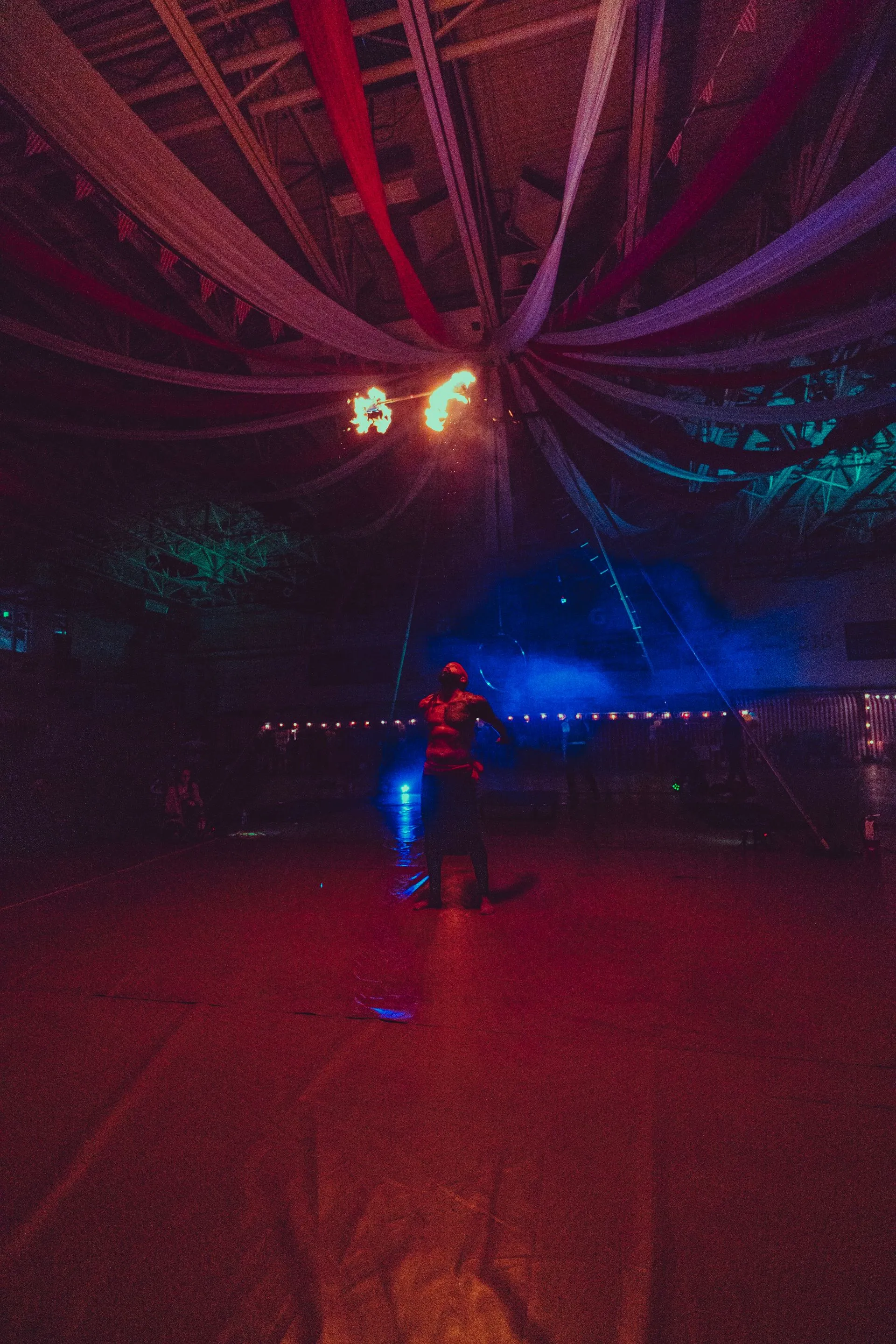 A person is dancing in a dark room with a lot of lights.