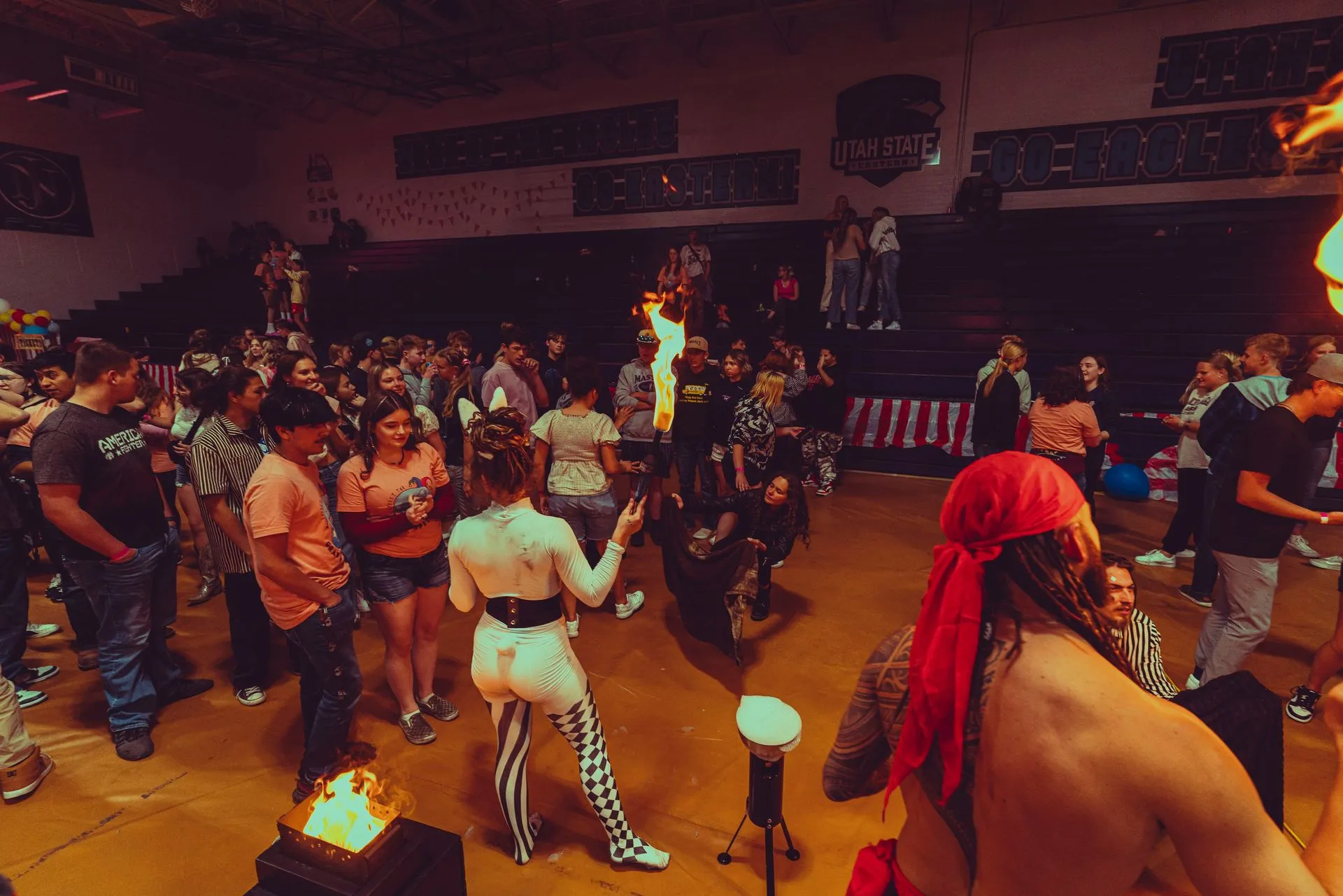 A group of people are dancing in a gym.