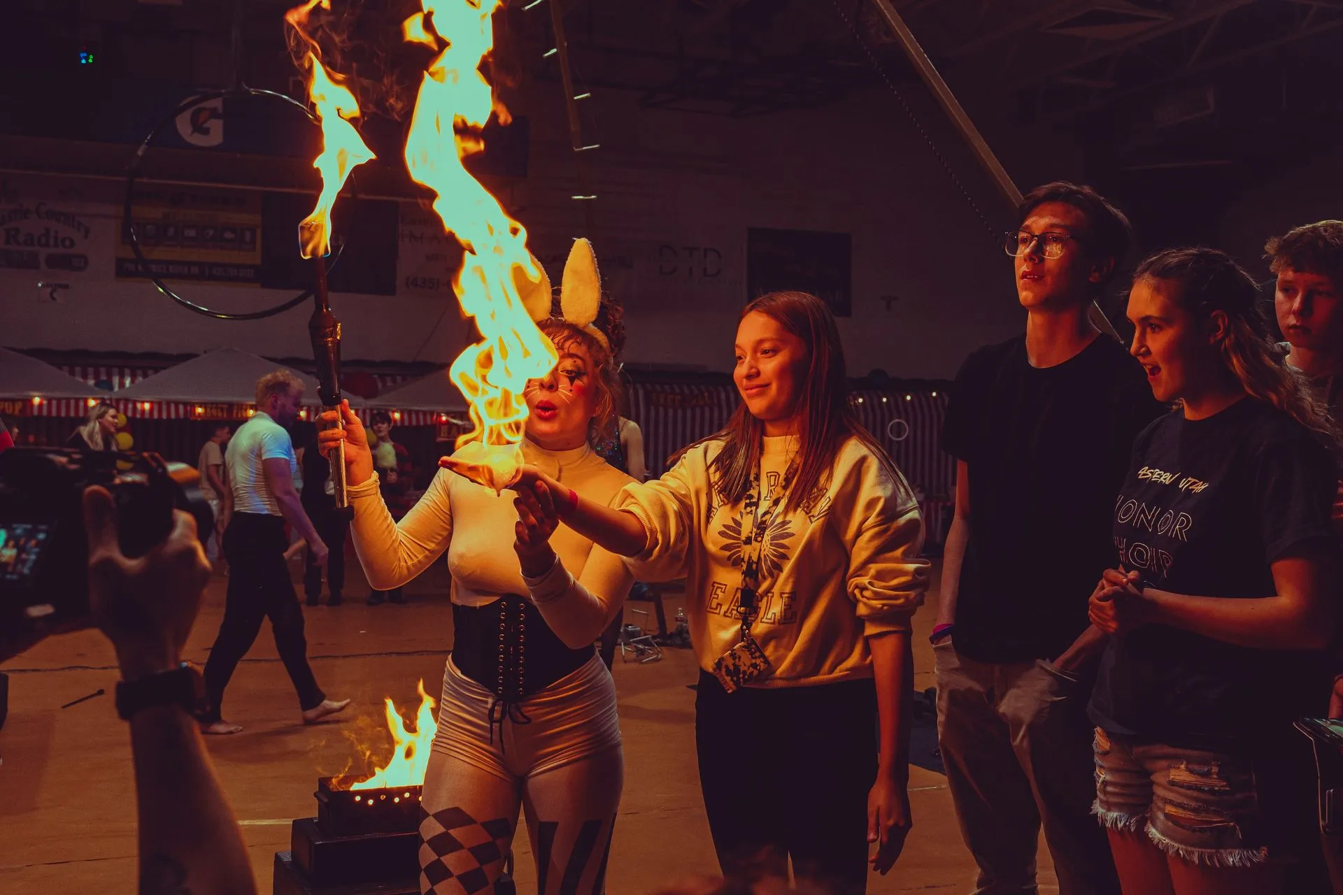 A woman is holding a torch with flames coming out of it.