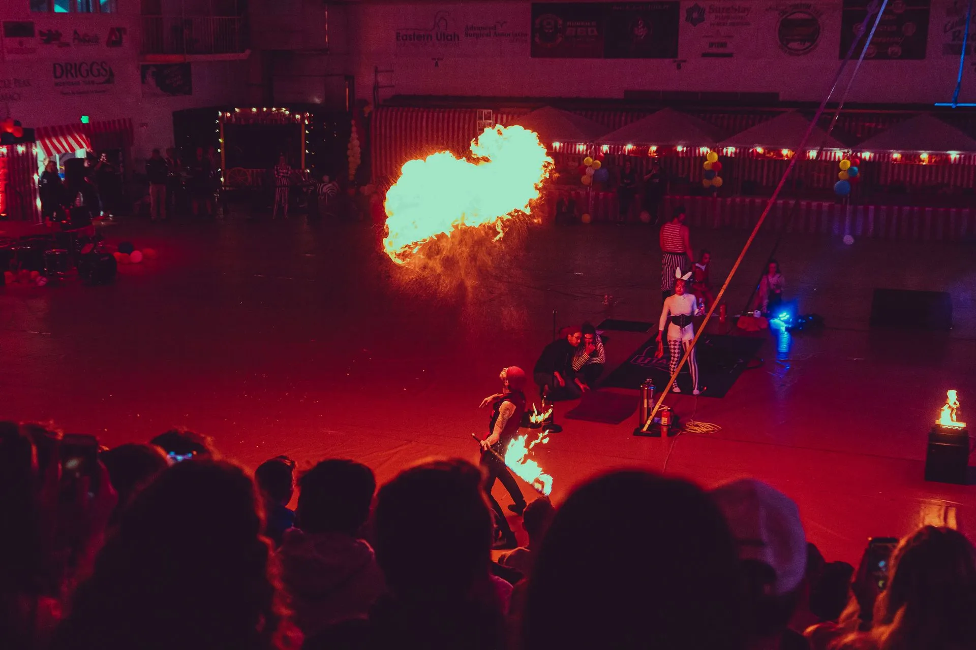 A group of people are watching a fire show in a stadium.
