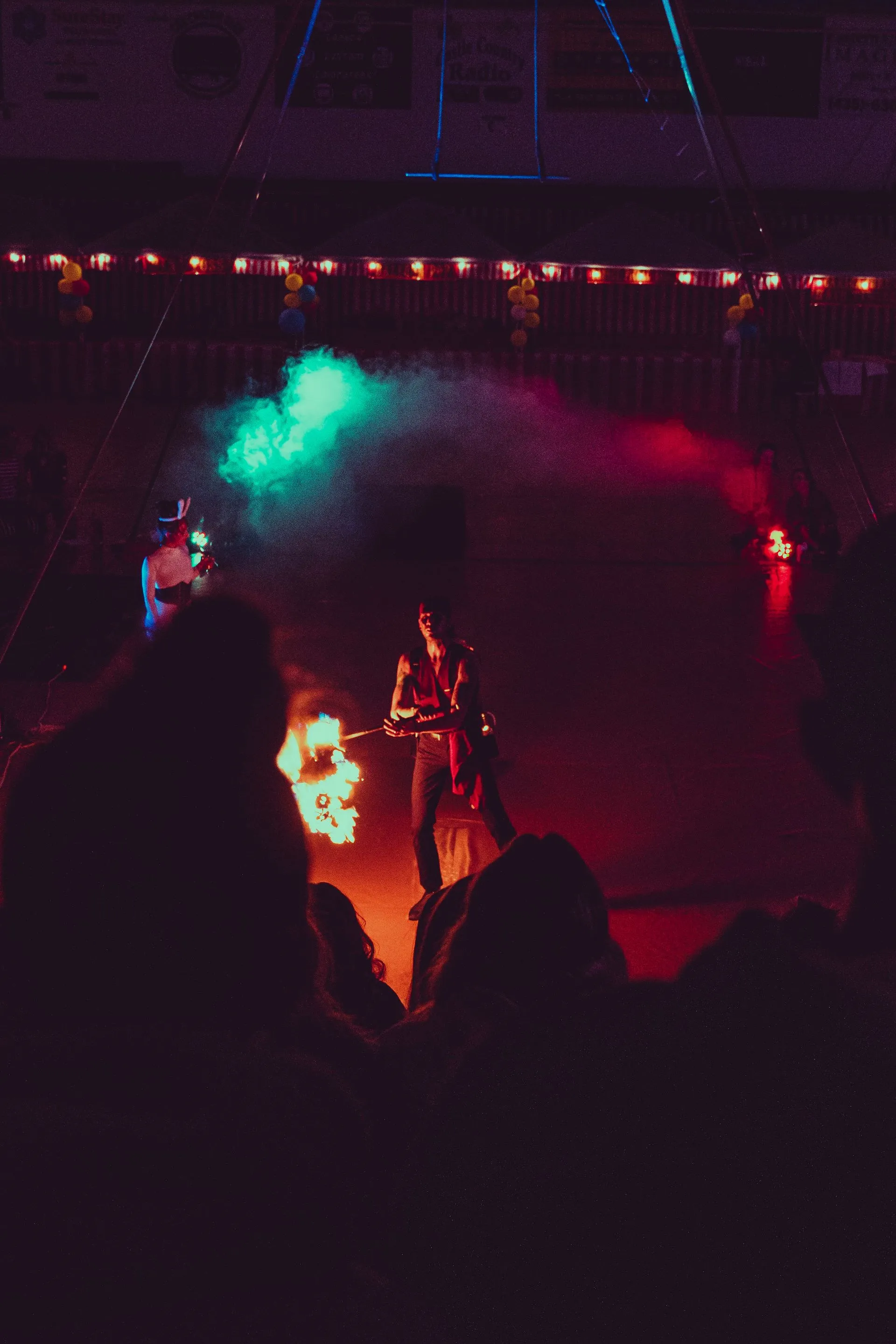A group of people are sitting in a dark room watching a fire show.