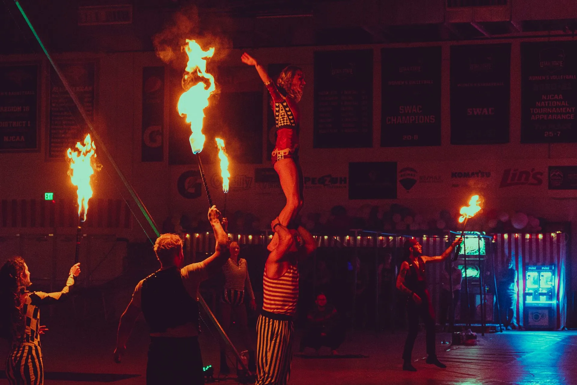 A group of people are performing a fire show in a gym.