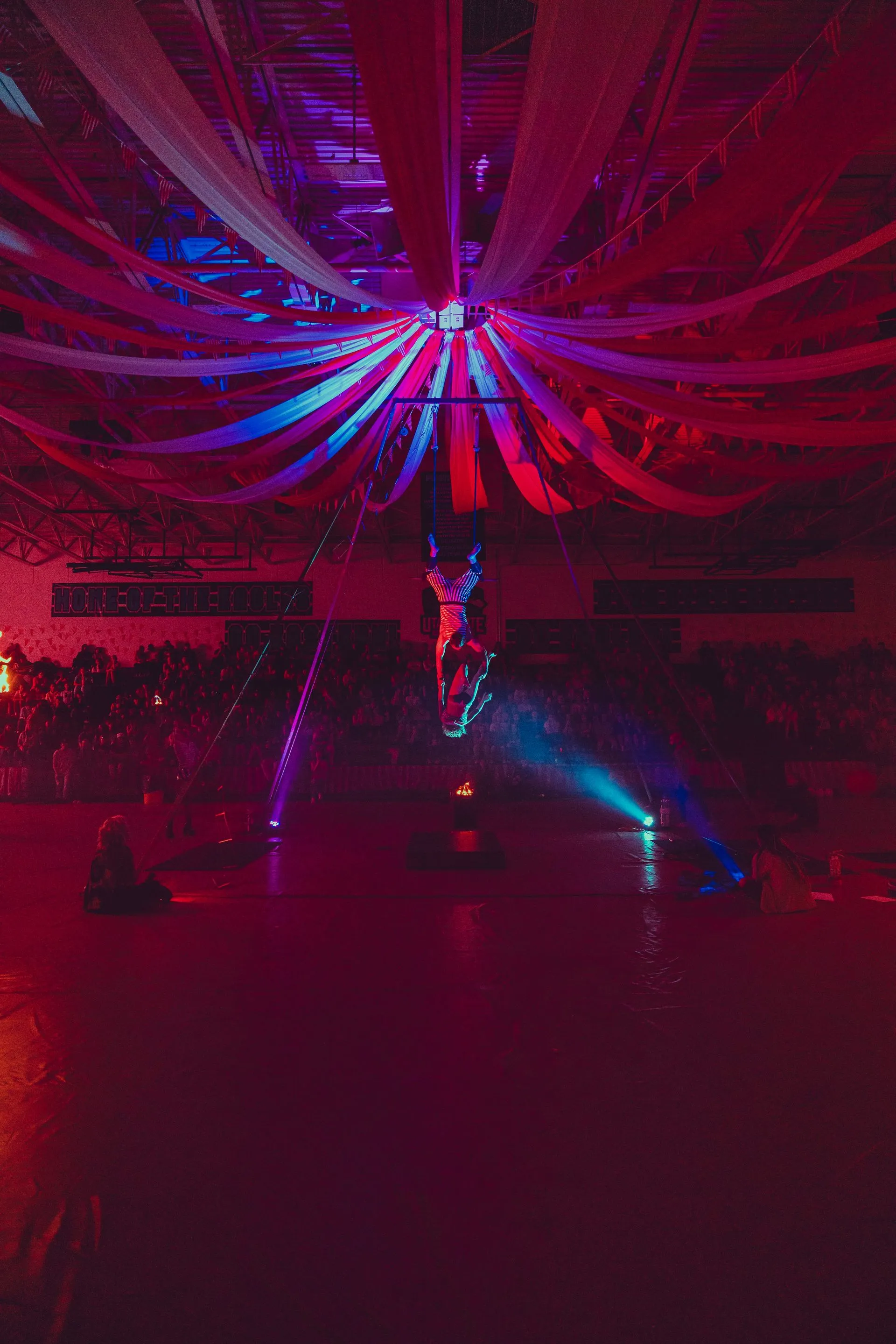 A person is doing aerial acrobatics in a dark room.