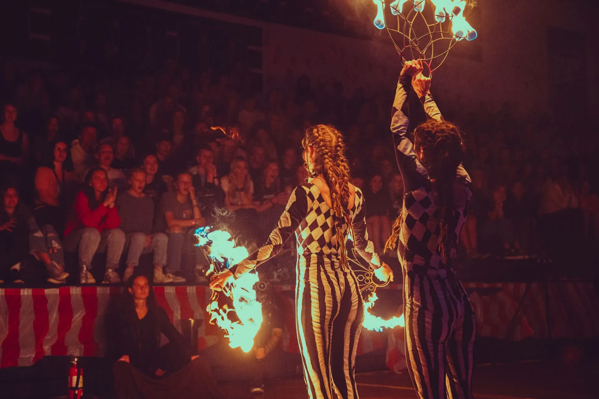 A group of people are performing a fire show in front of a crowd.