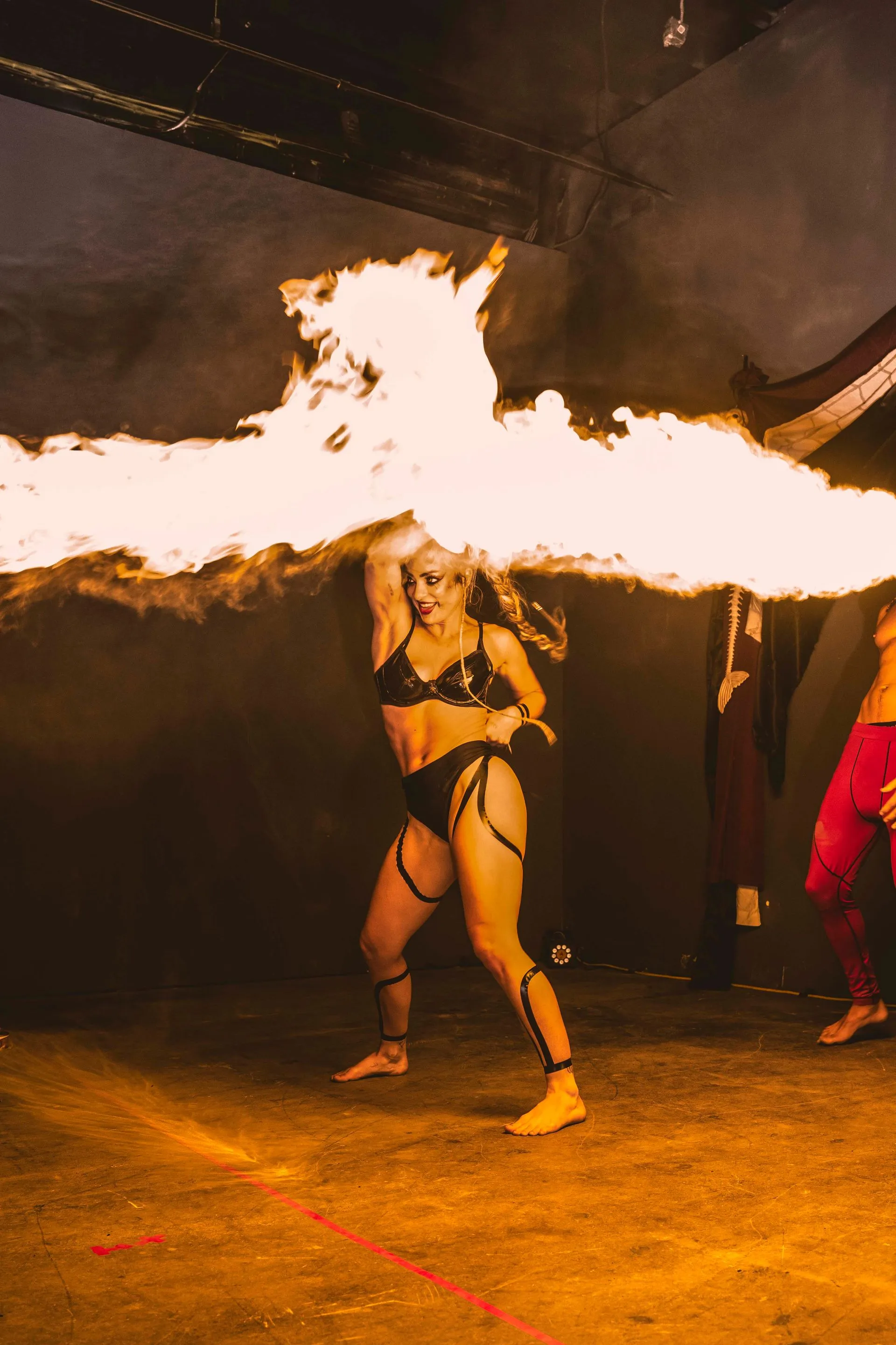 A woman in a bikini is holding a stick of fire.