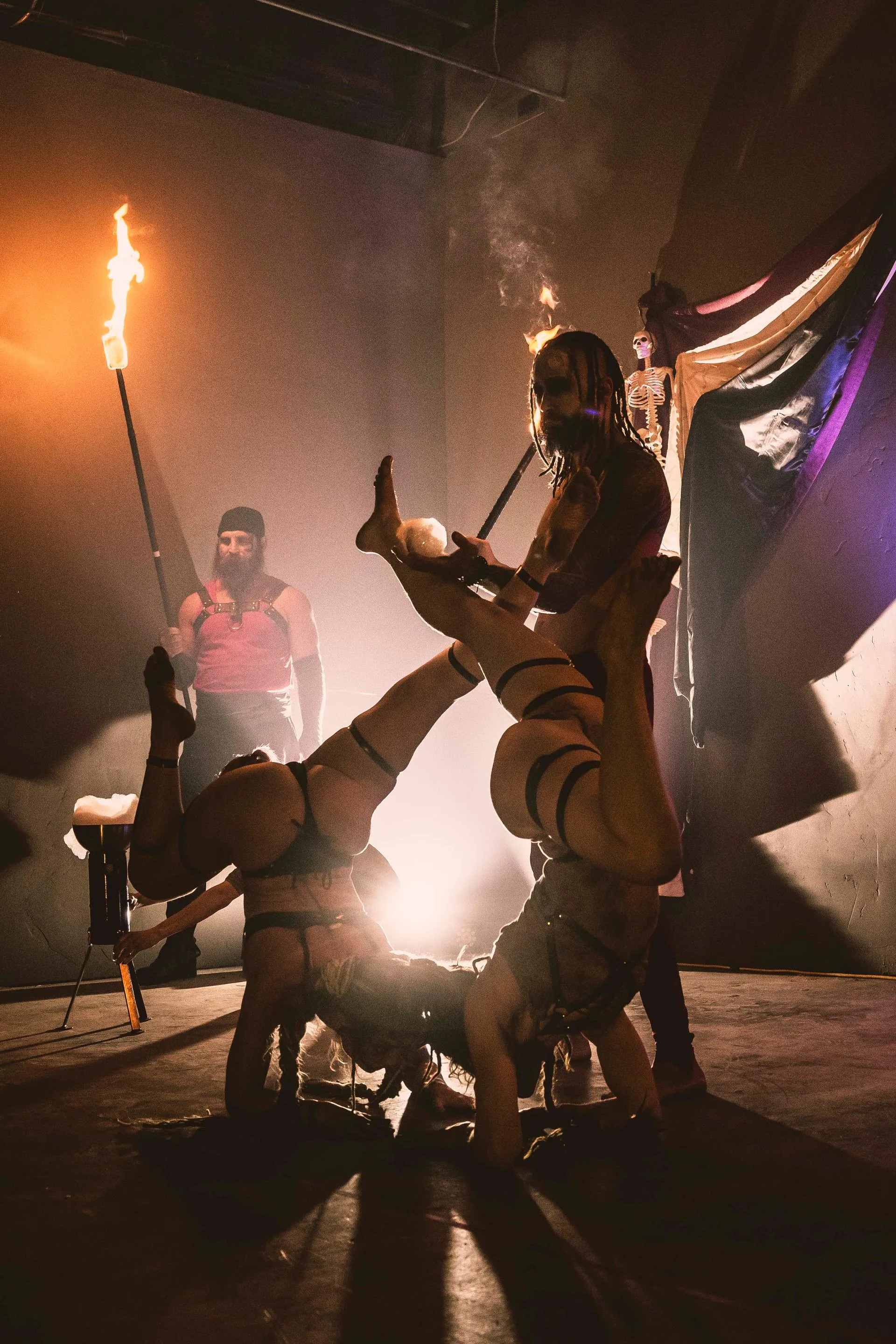 A group of people are performing acrobatics in a dark room.