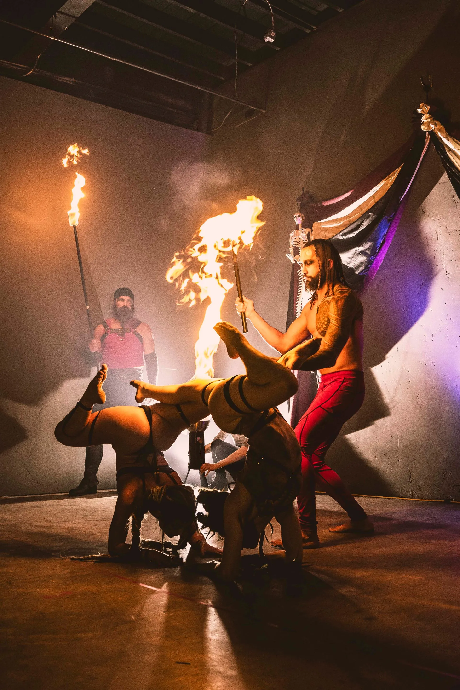 A group of people are performing a fire show in a dark room.