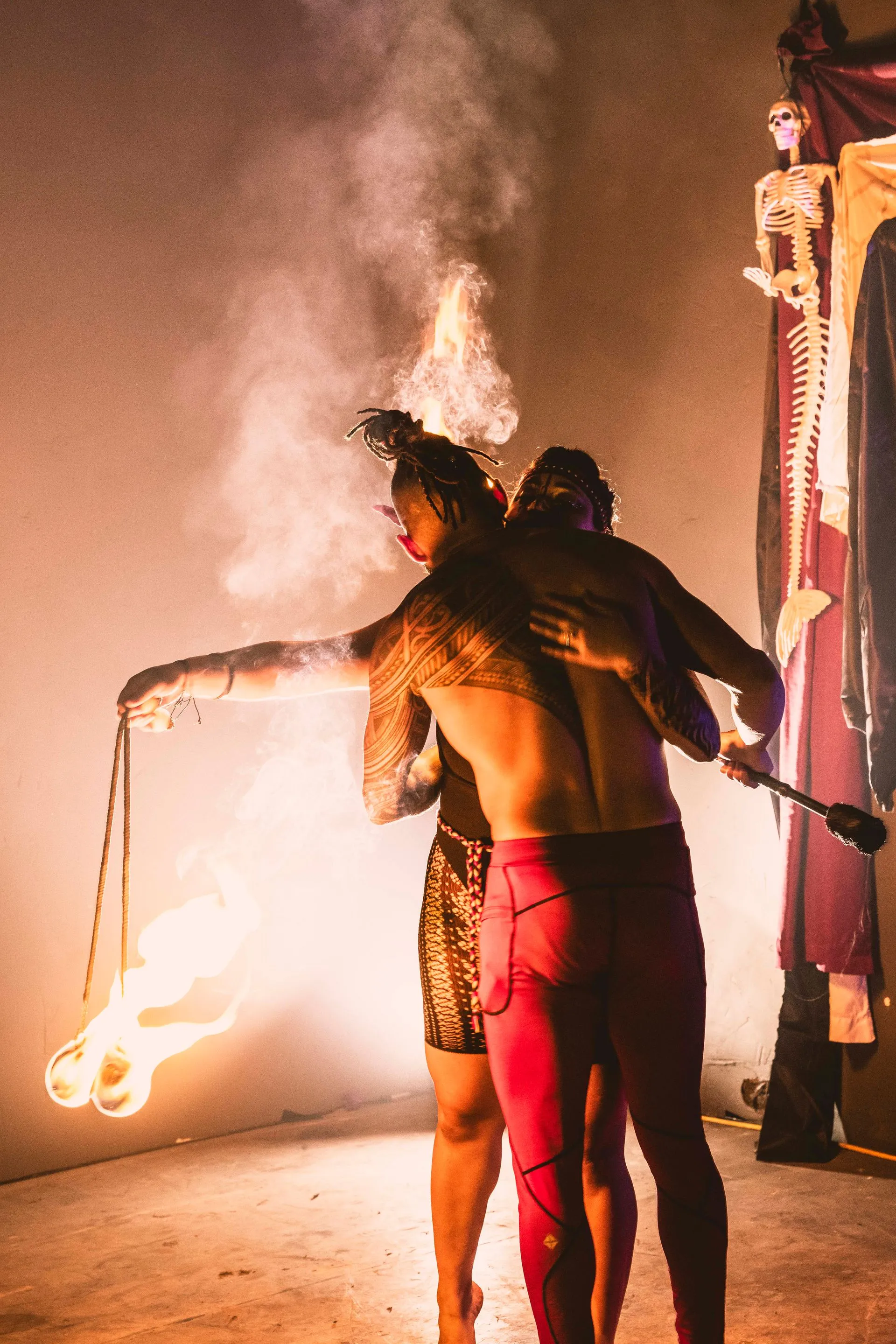 A couple of people standing next to each other holding a fire torch.